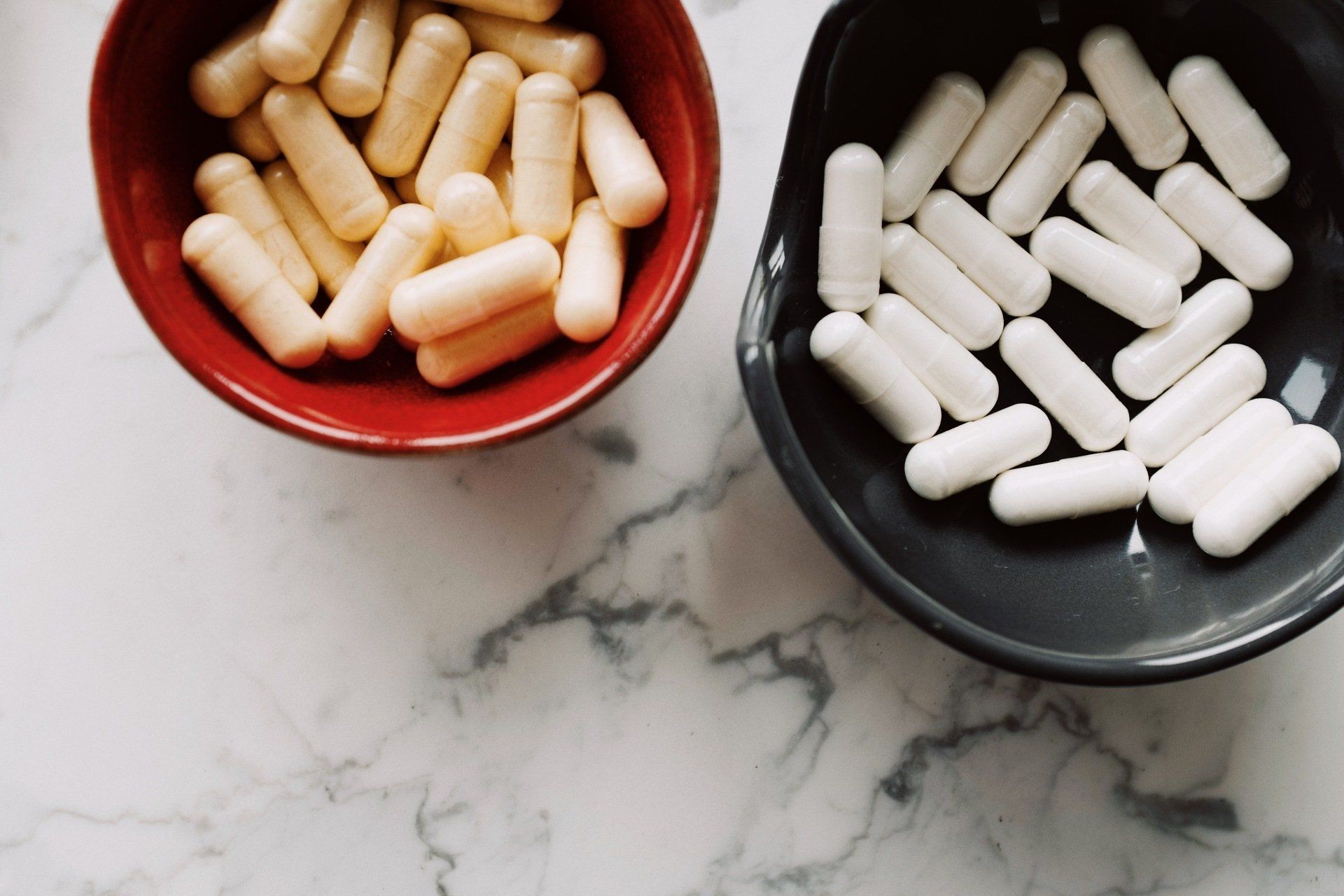 Two bowls of pills are sitting on a table.