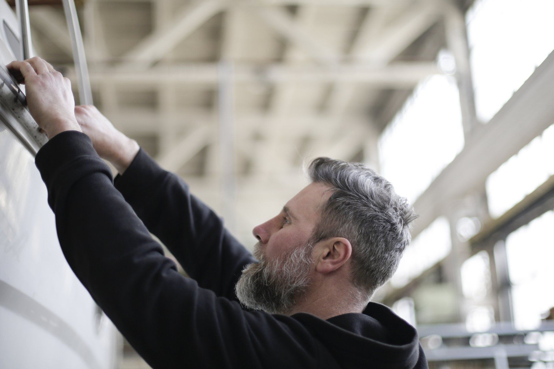 a man with a beard is working on a boat in a factory .