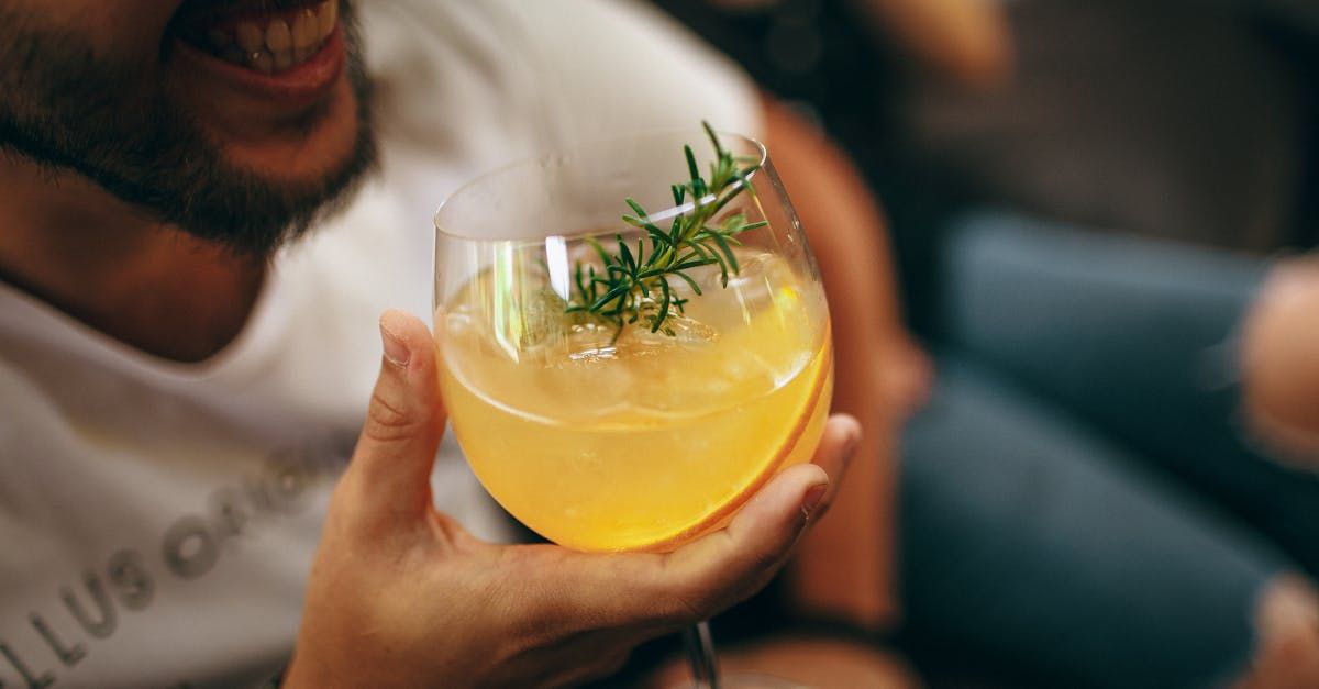 Un uomo tiene in mano un bicchiere per aperitivo