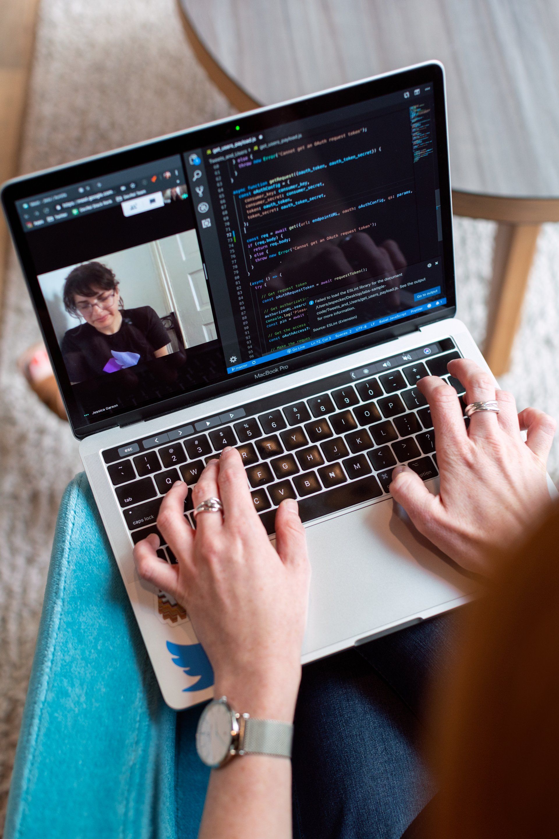 A person is typing on a laptop computer with a picture of a man on the screen.