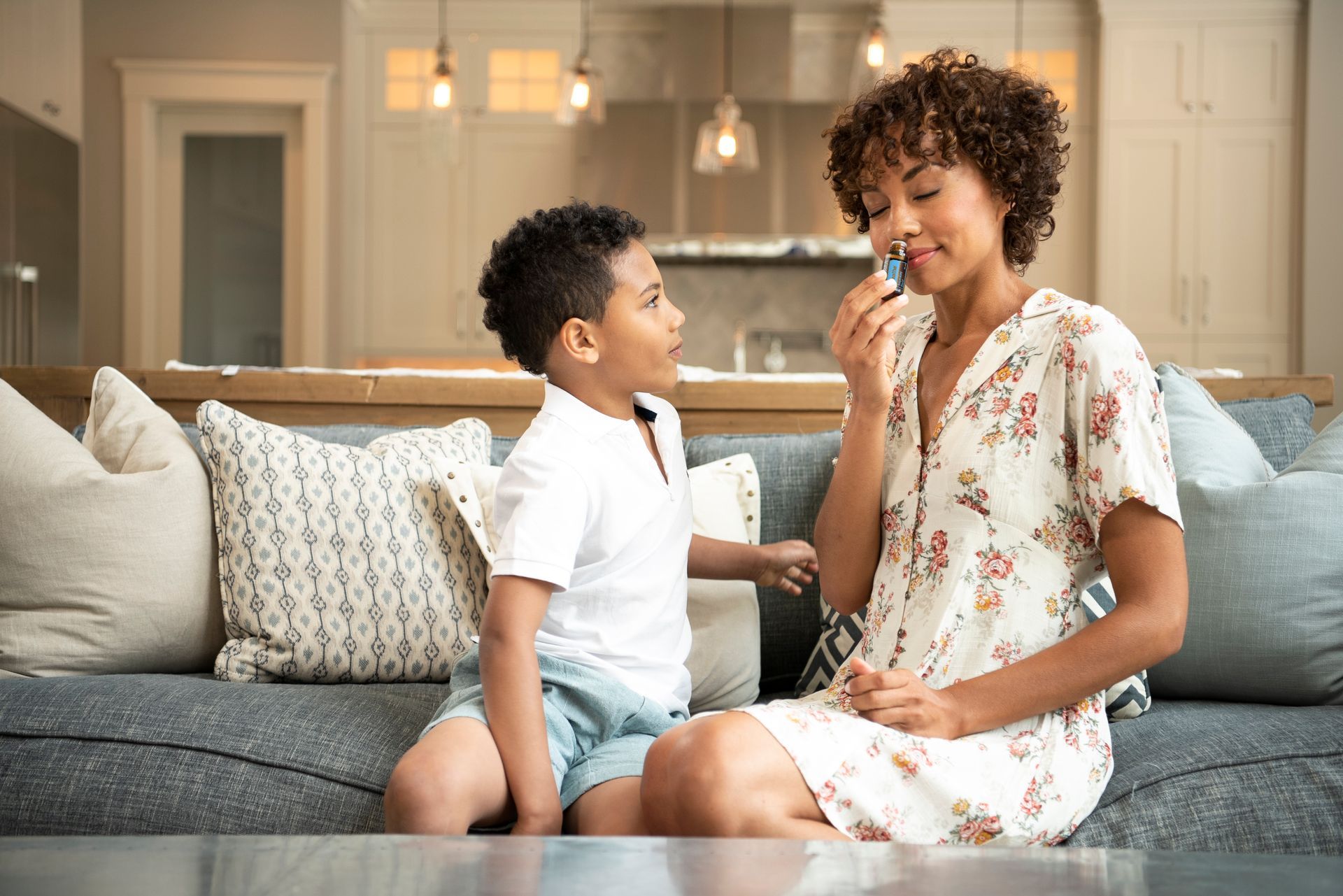 A woman and a boy are sitting on a couch in a living room.