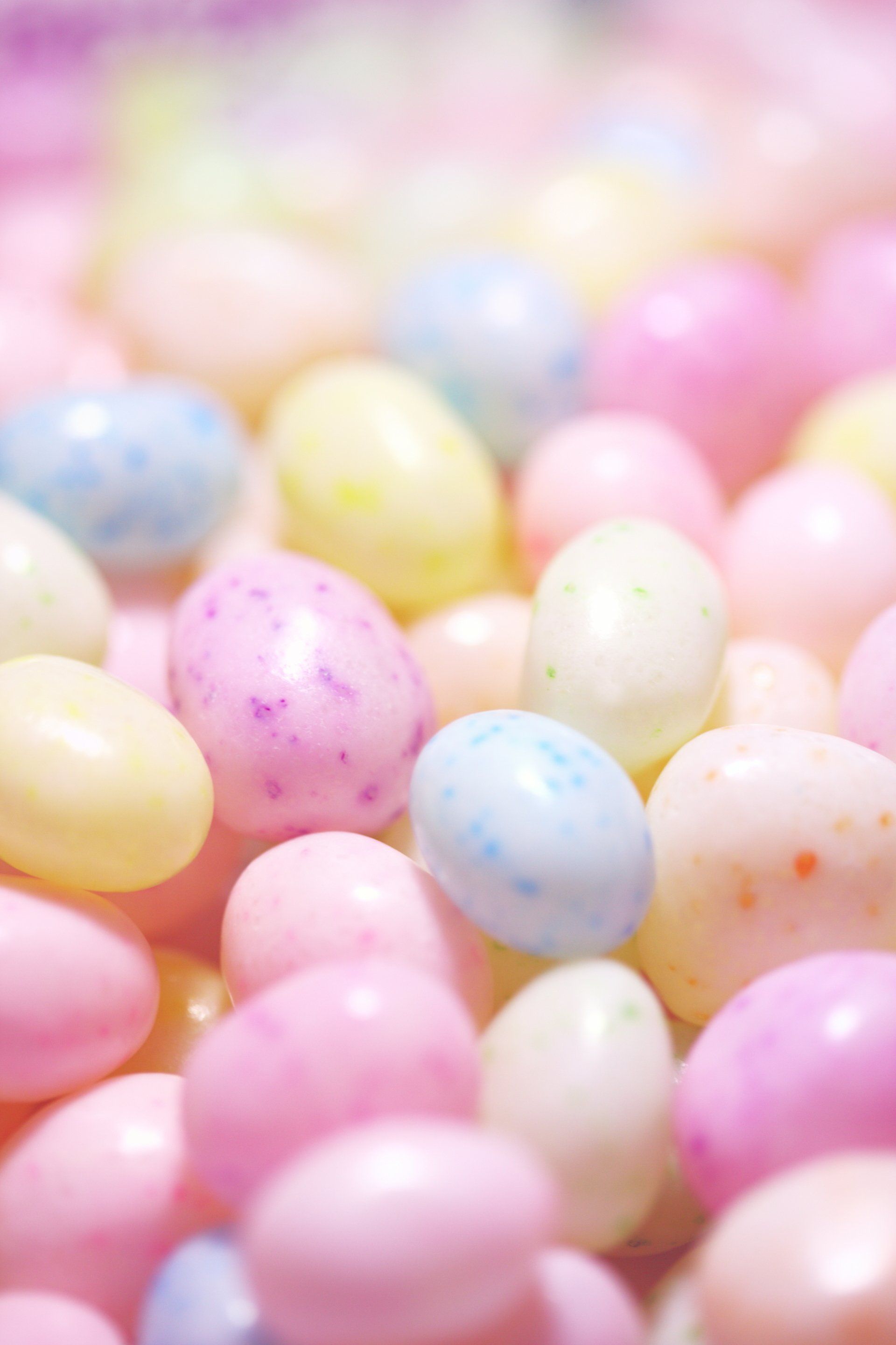 A pile of pink , yellow , and blue jelly beans.