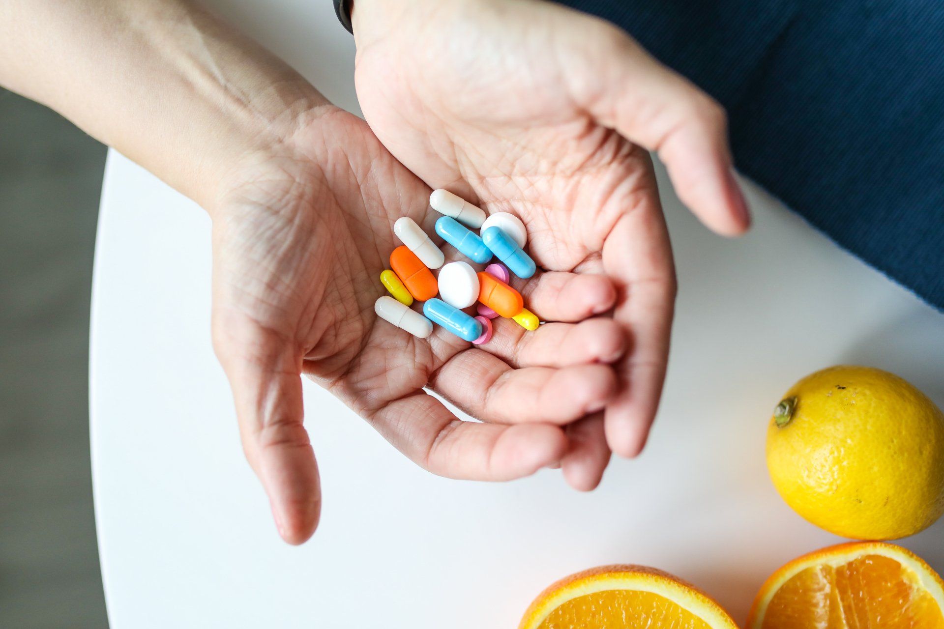 A person is holding a bunch of pills in their hands.