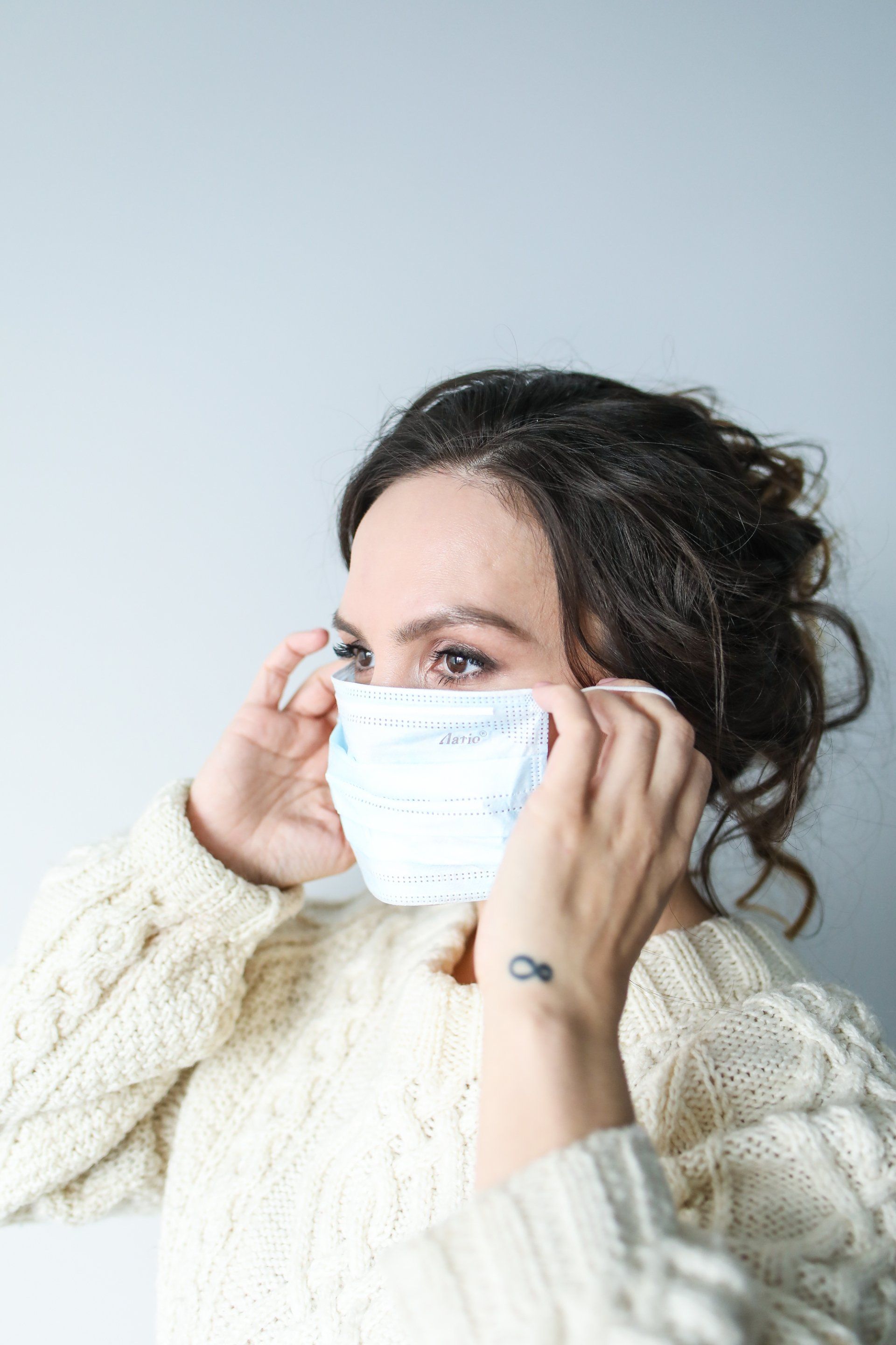 A woman is wearing a medical mask on her face.