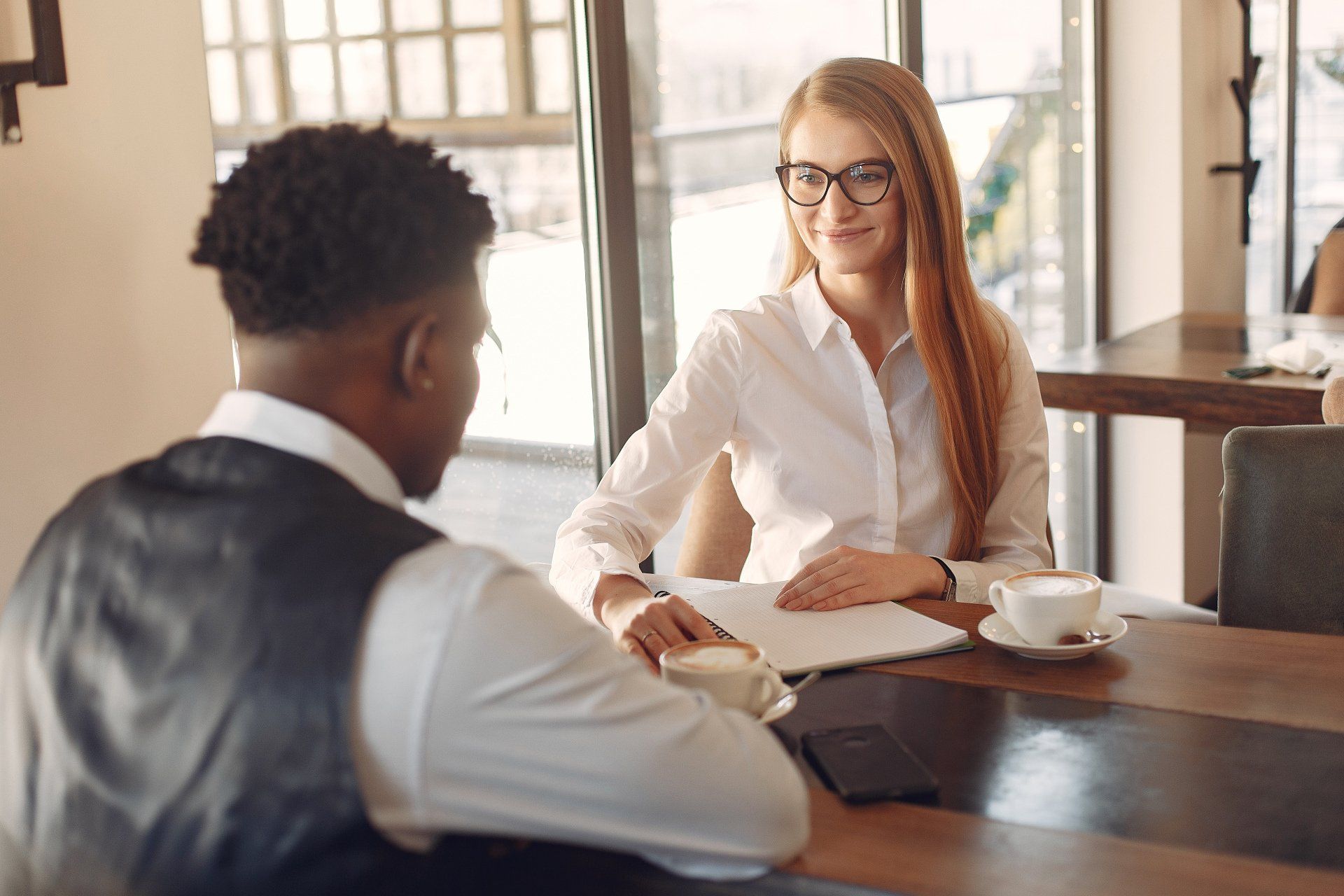 A man and a woman are sitting at a table having a job interview.