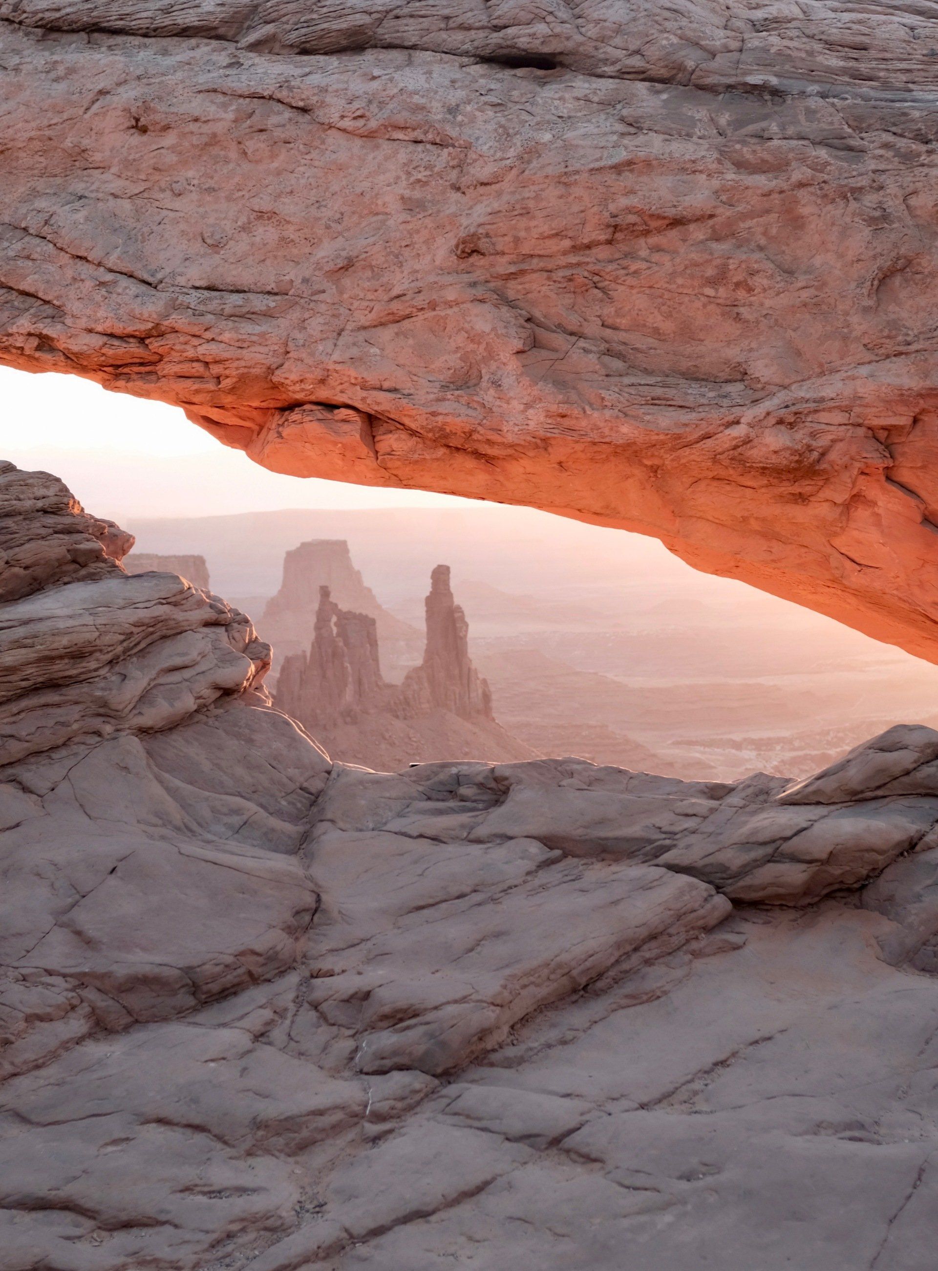 A view of a desert landscape through a rock arch.
