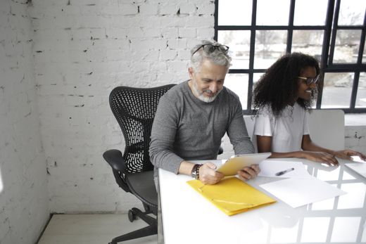 A man and a woman are sitting at a table looking at papers.