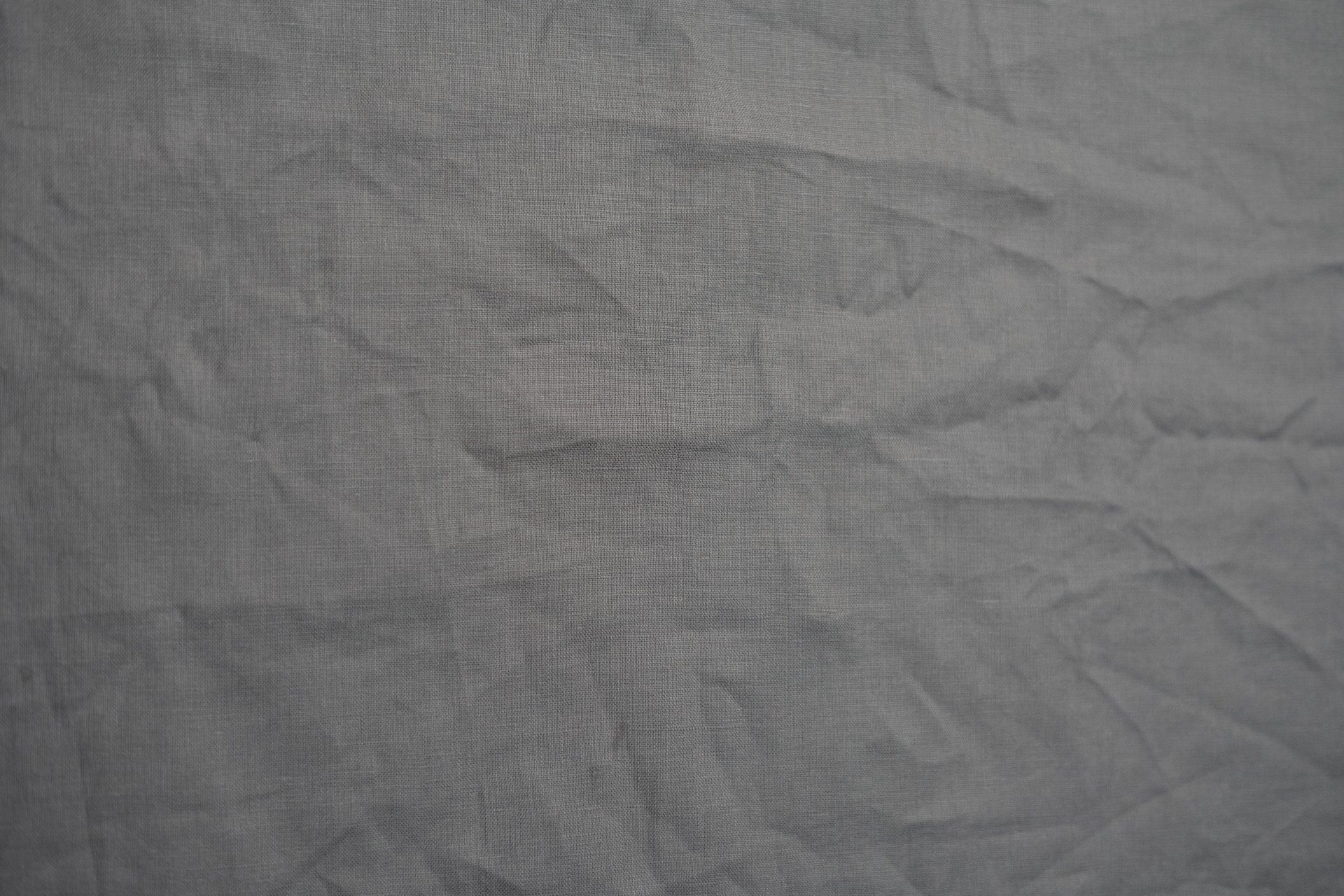 Gray wrinkled fabric surface with subtle textured folds