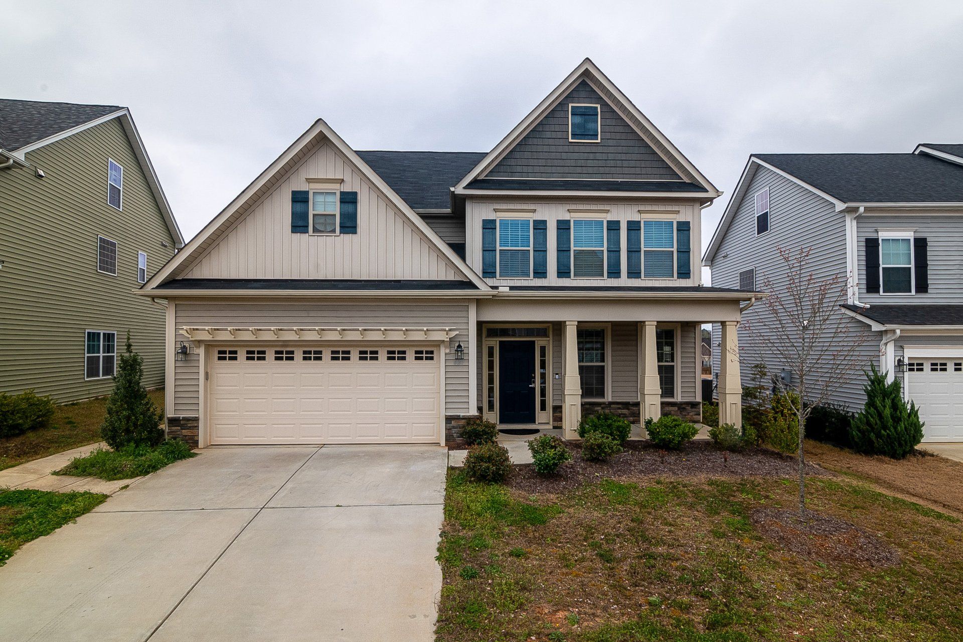 A large house with a large garage and a porch.