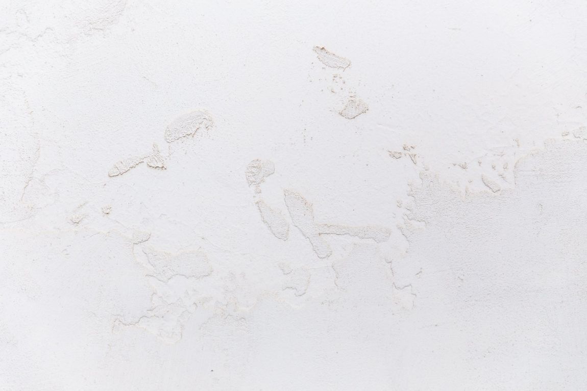 Footprints on a white plaster wall, possibly inside a building.