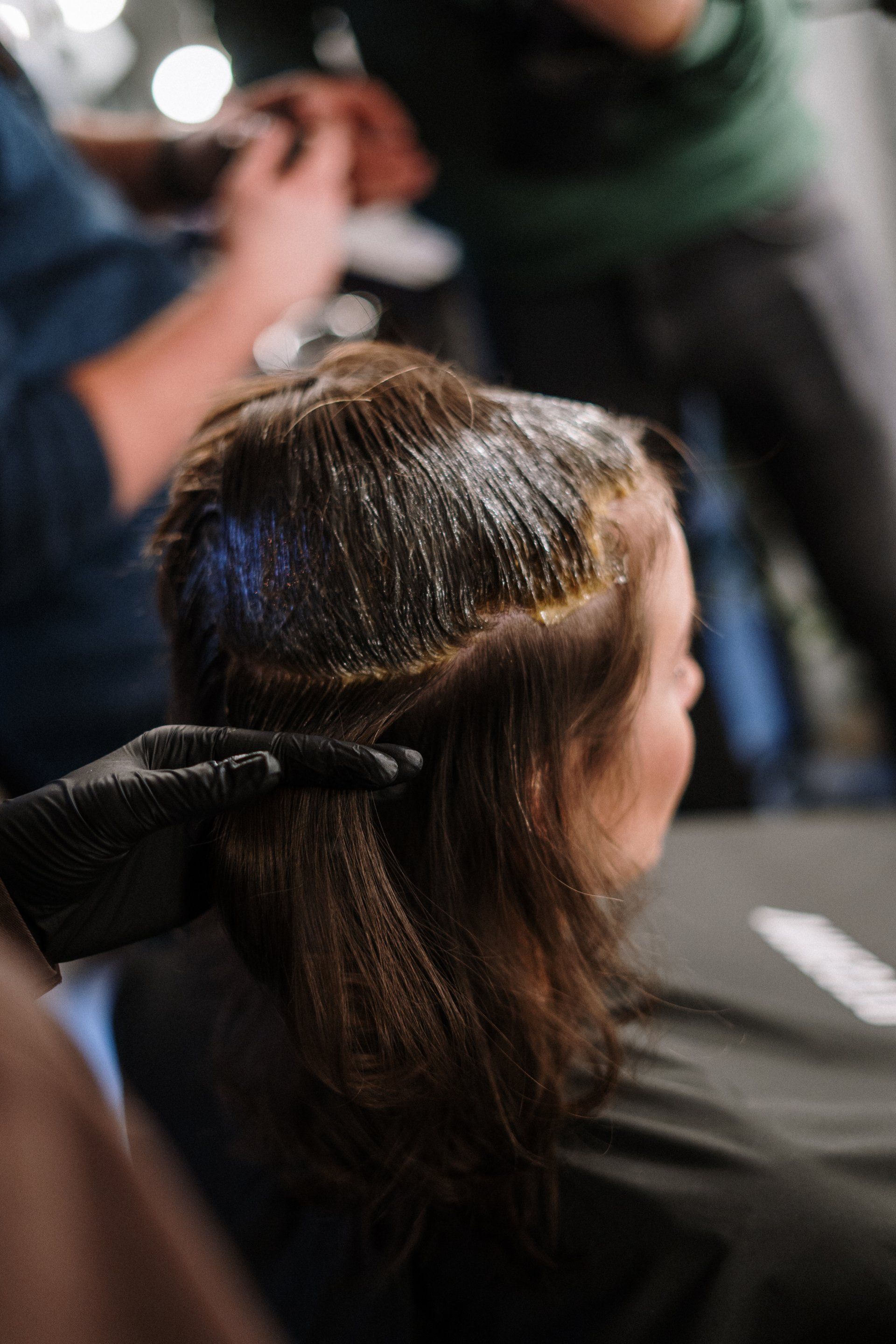 A woman is getting her hair dyed at a salon.