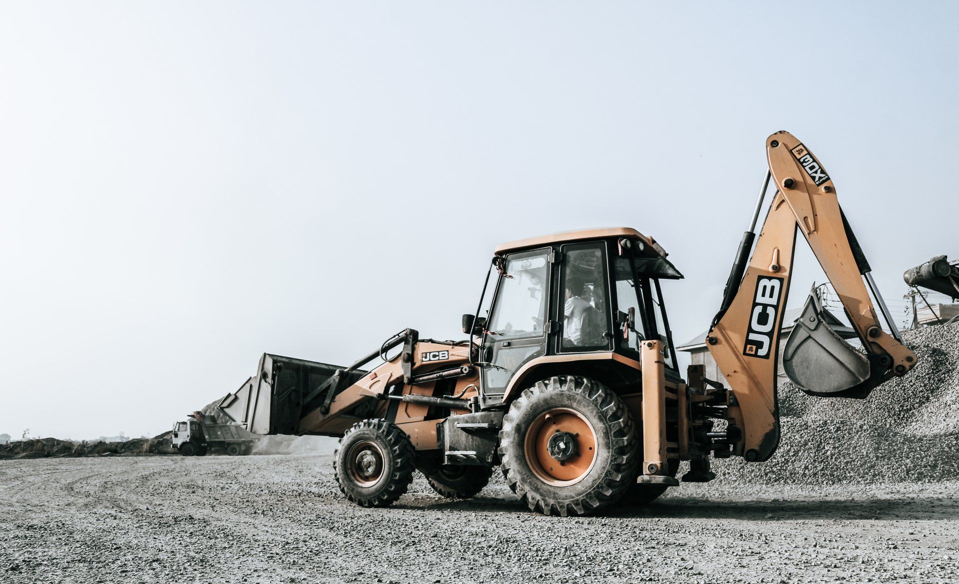 A bulldozer is sitting on top of a pile of gravel.