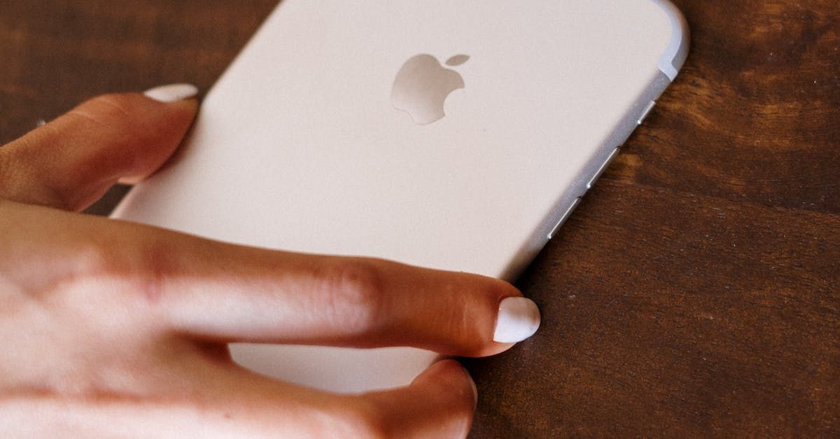 a person is holding a white apple iphone in their hand