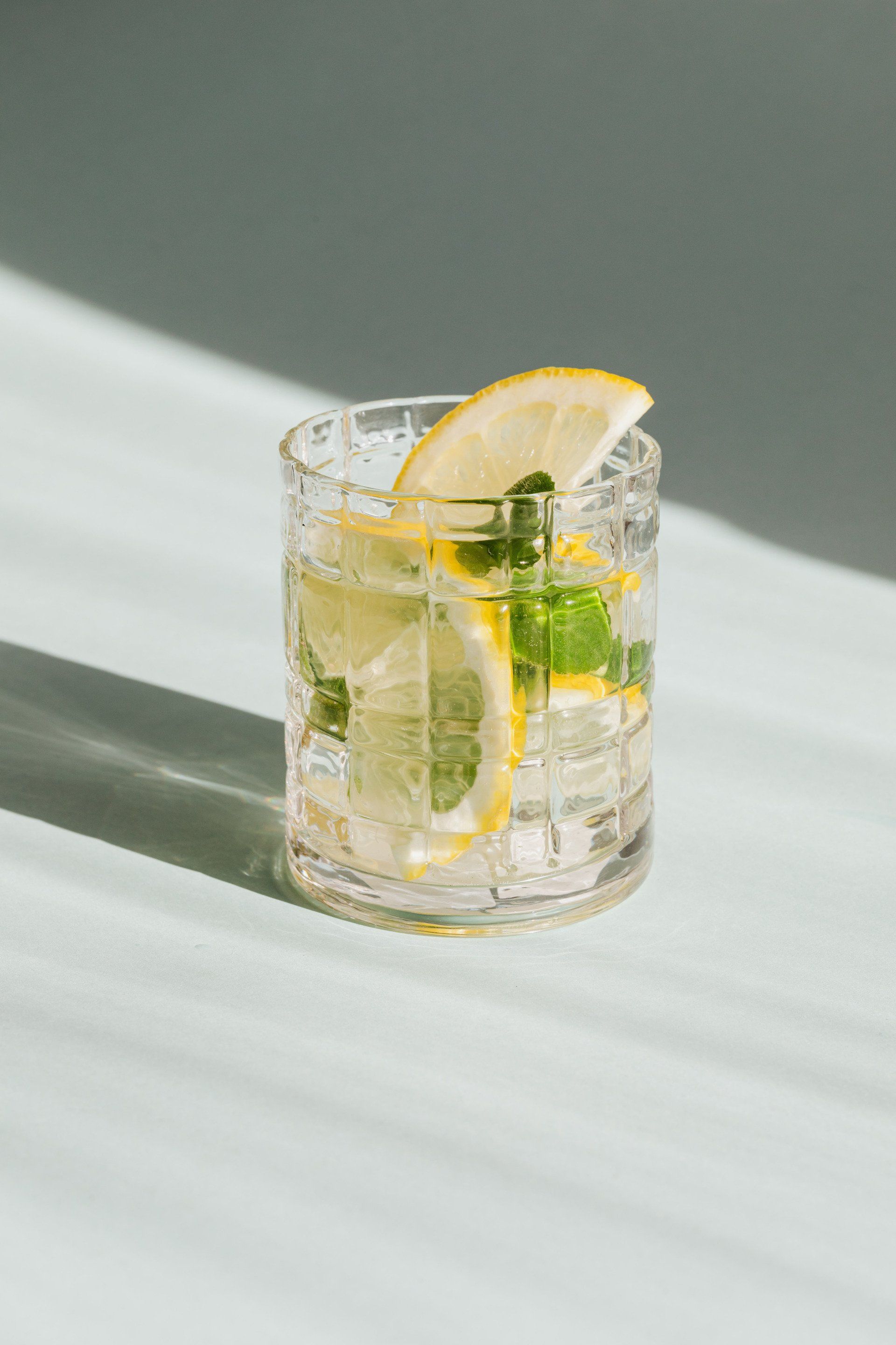 cold glass of lemon aid, with lemons and ice and spearmint 