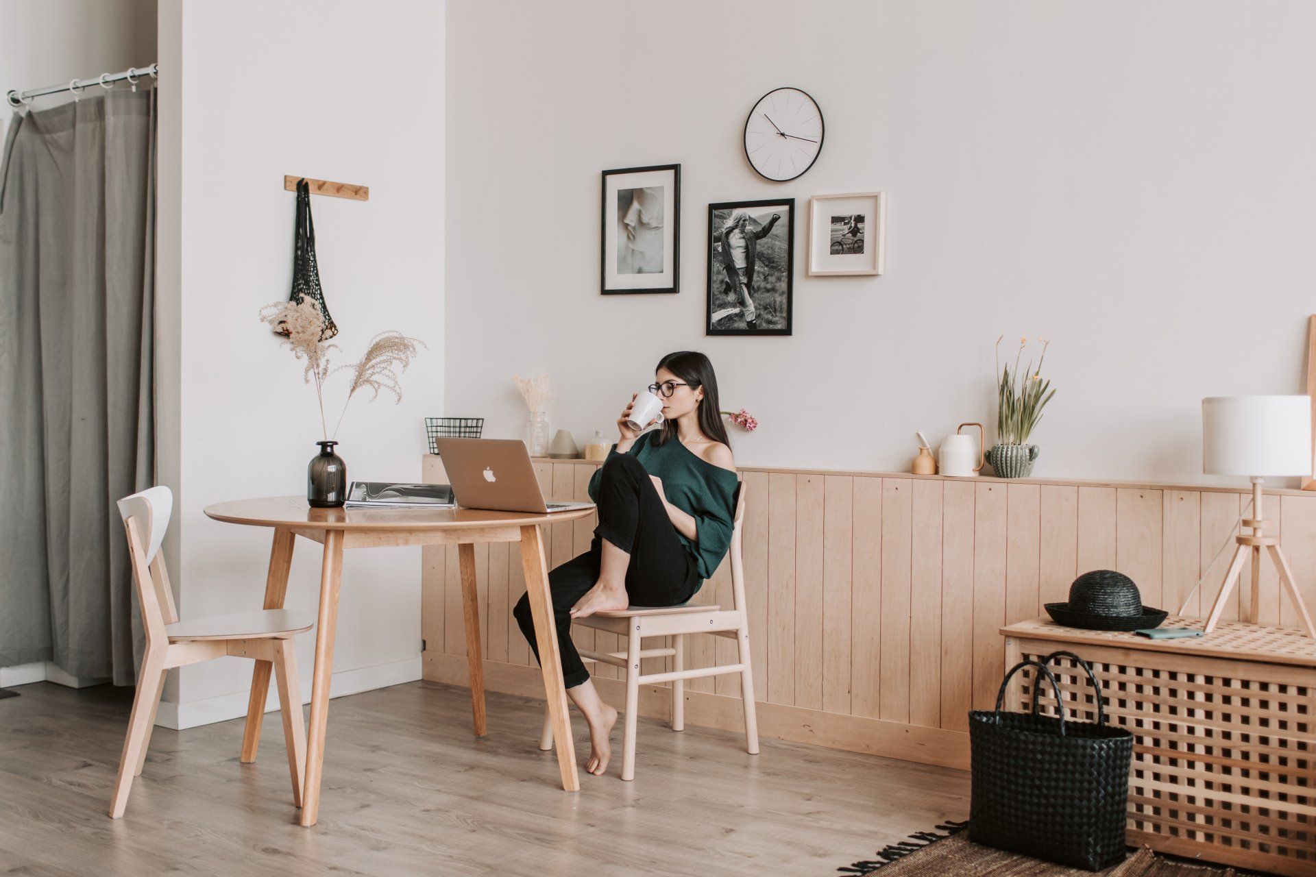 woman sitting at a table drinking out of a ceramic cup