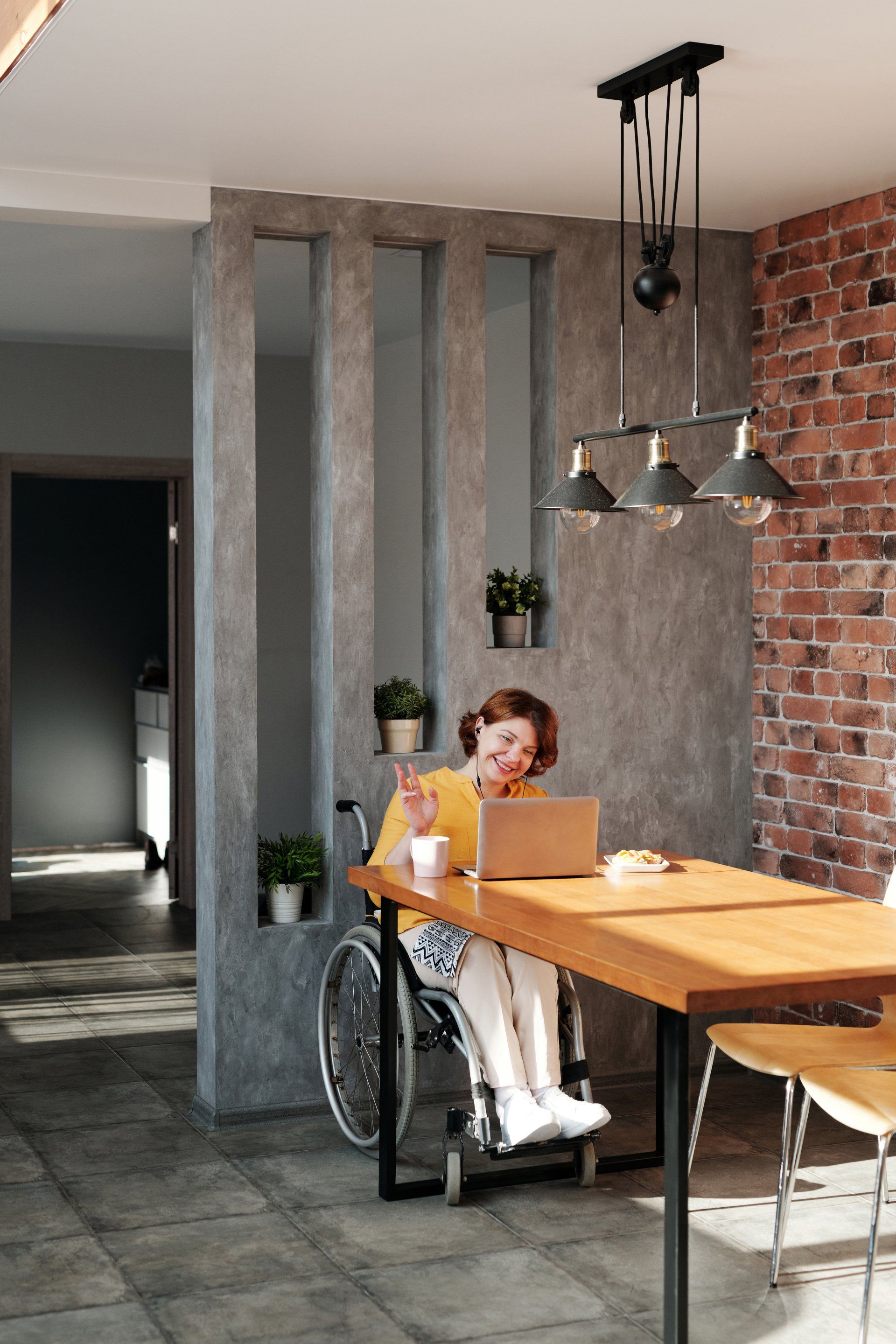 Woman in wheelchair talking on a laptop - HR Software