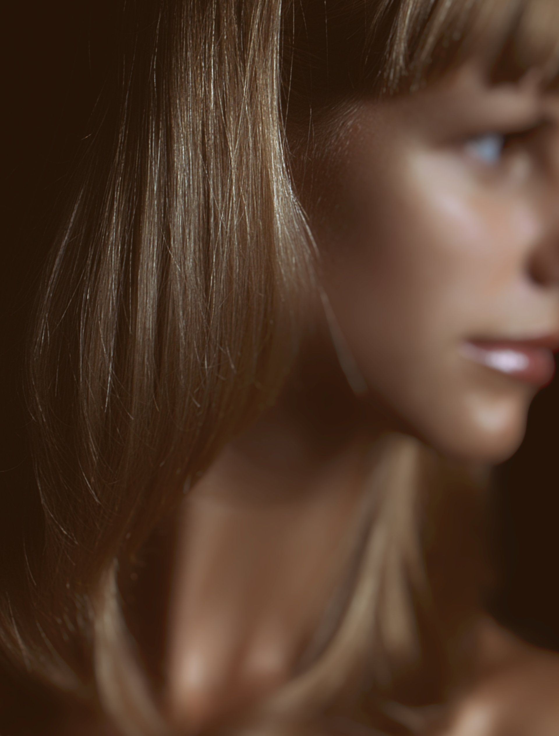 A close up of a woman 's face with a dark background