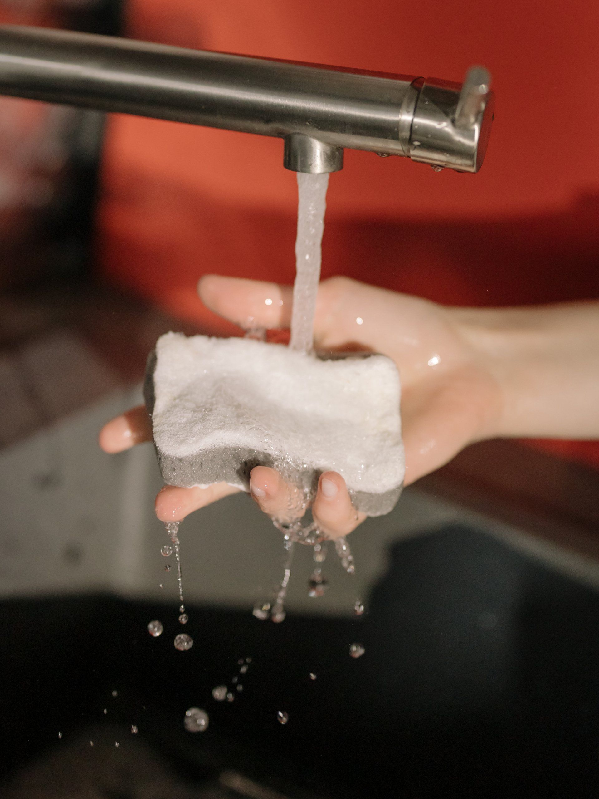 cleaning a sponge in the faucet