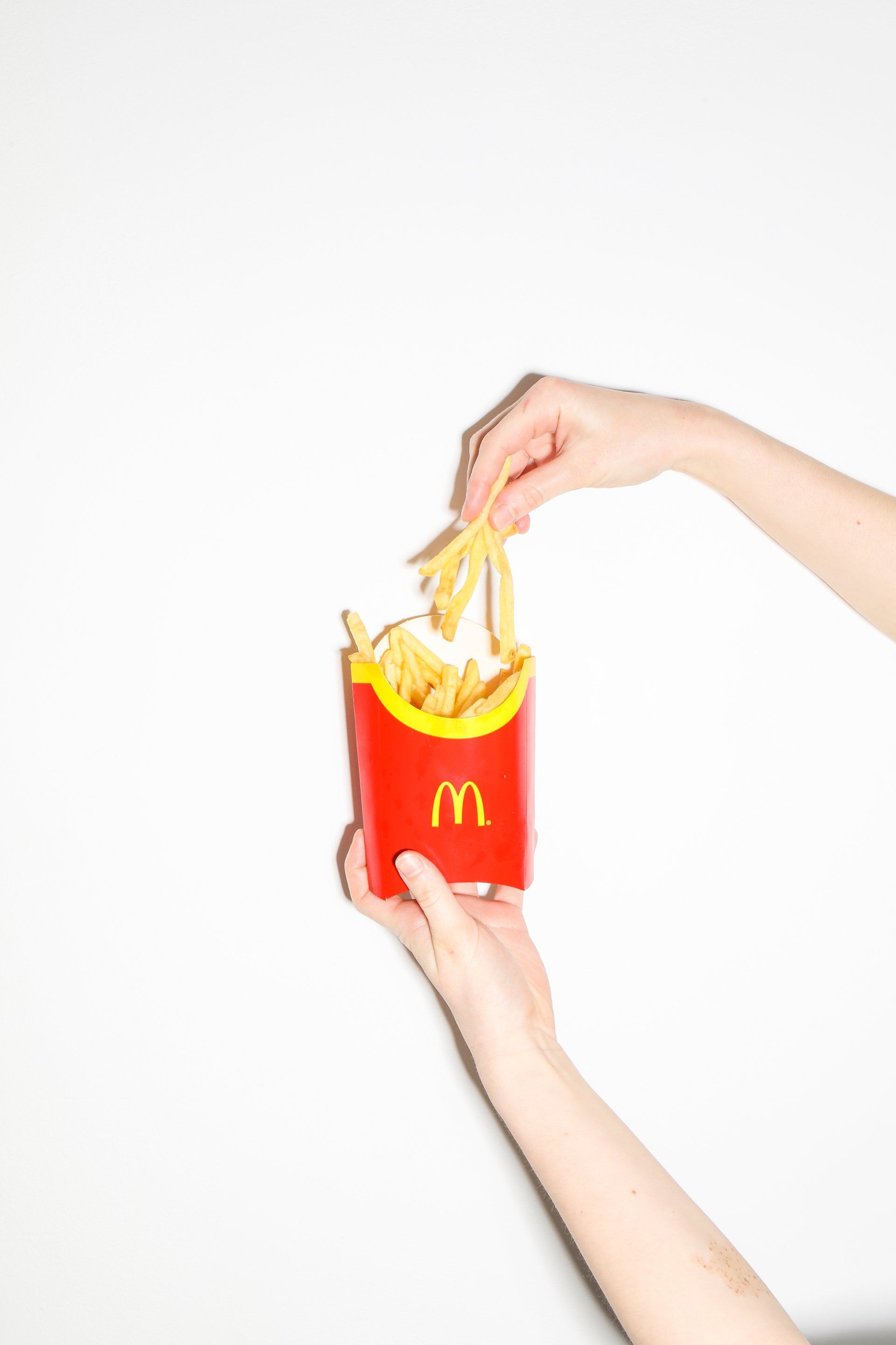 Uma pessoa está segurando um saco de batatas fritas do McDonald's.