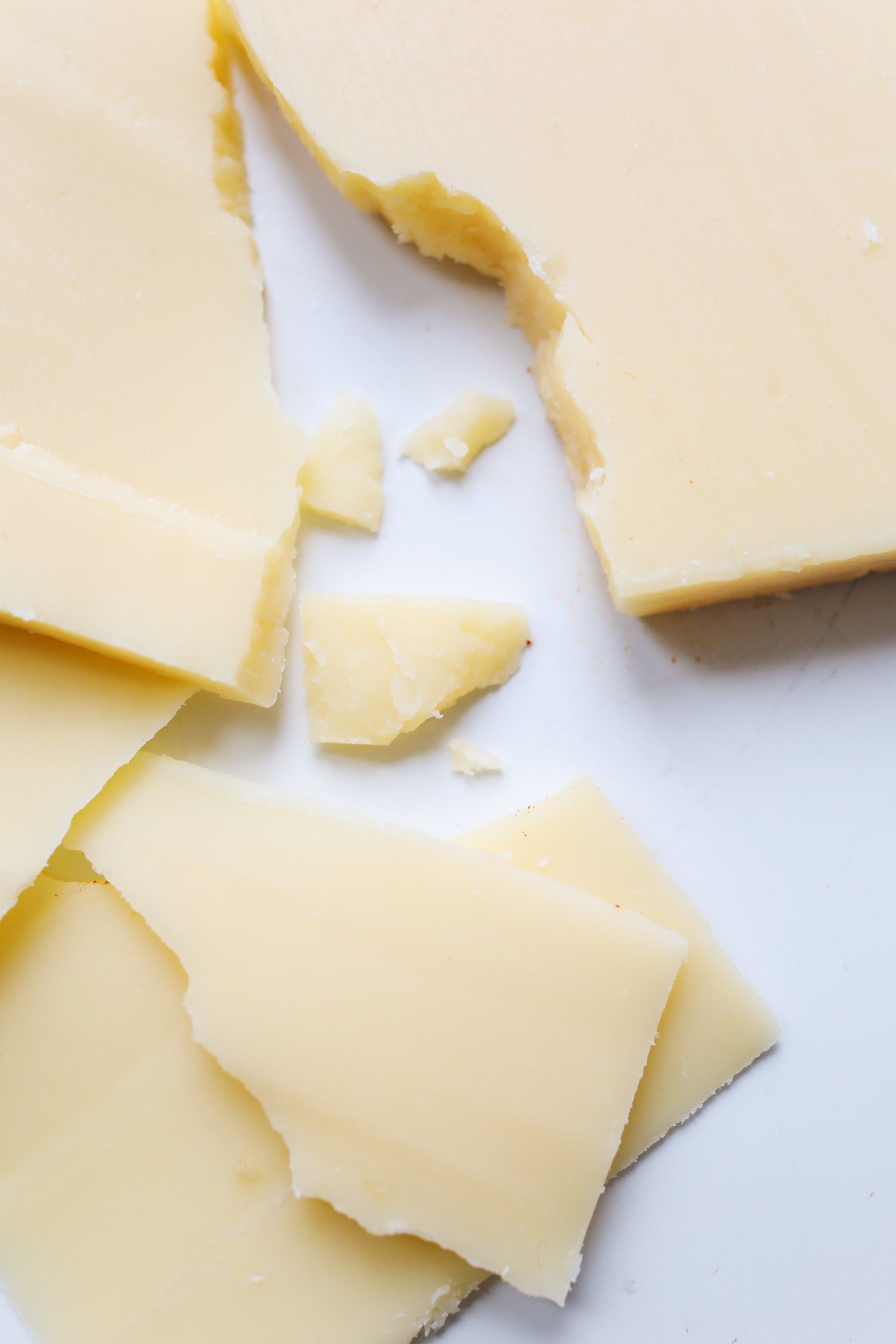 A close up of a piece of cheese on a white plate