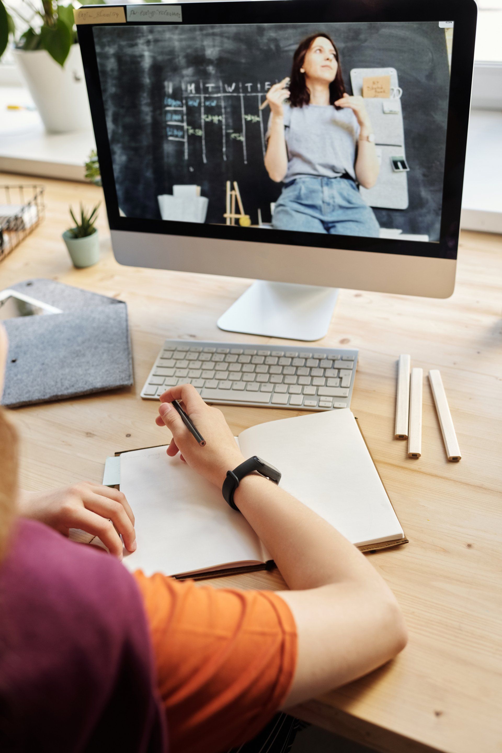 A person is sitting at a desk looking at a computer screen.