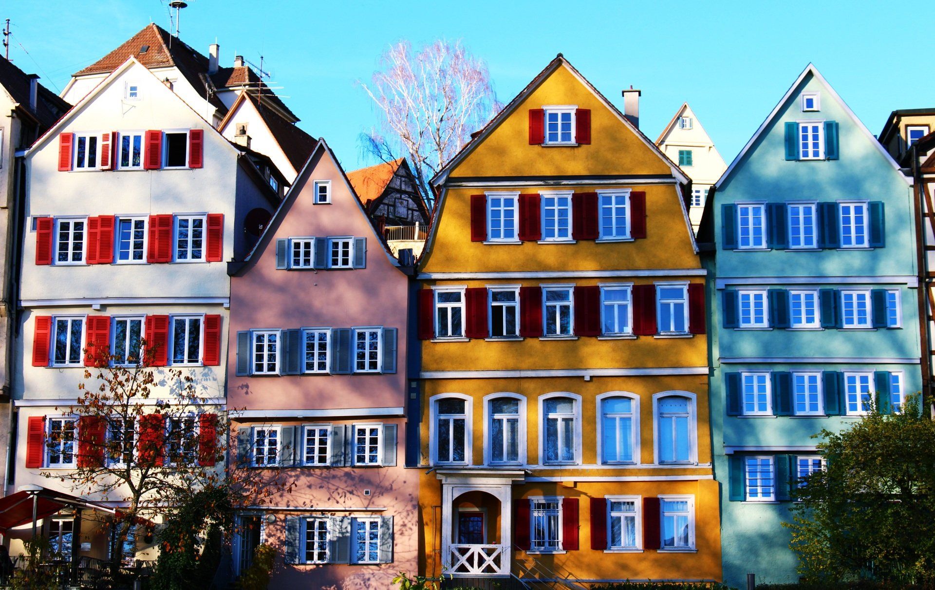 A row of colorful buildings with red and white shutters