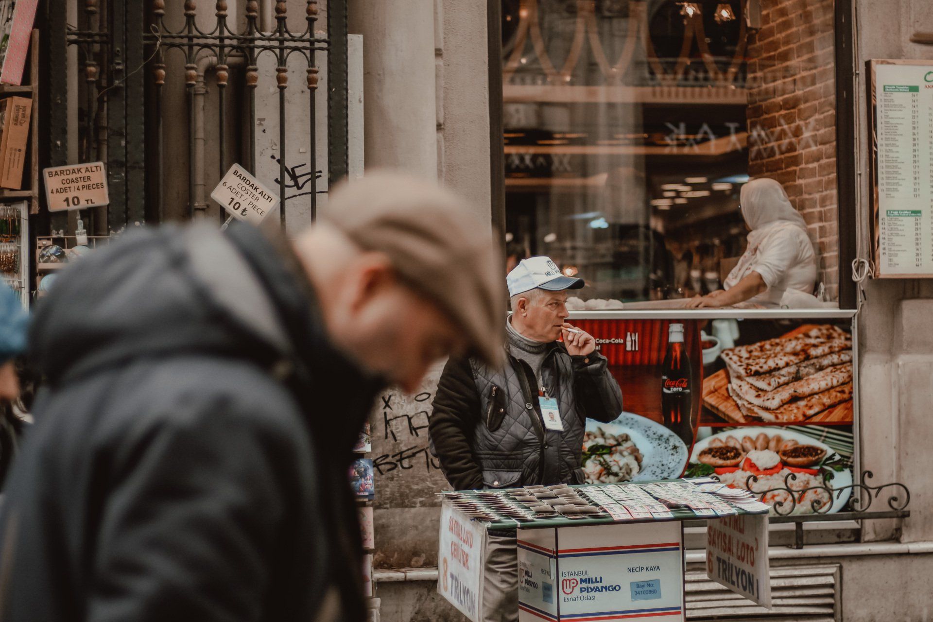 A man is standing in front of a bakery looking at food.