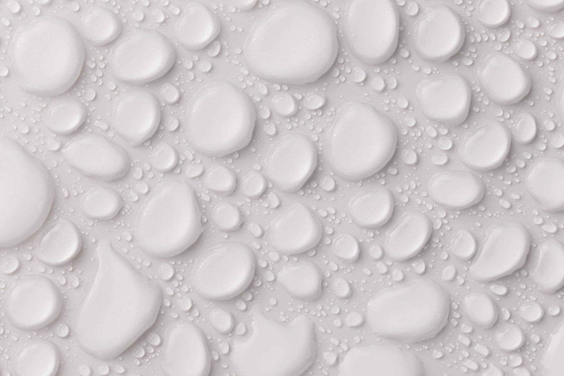 A close up of water drops on a white surface.