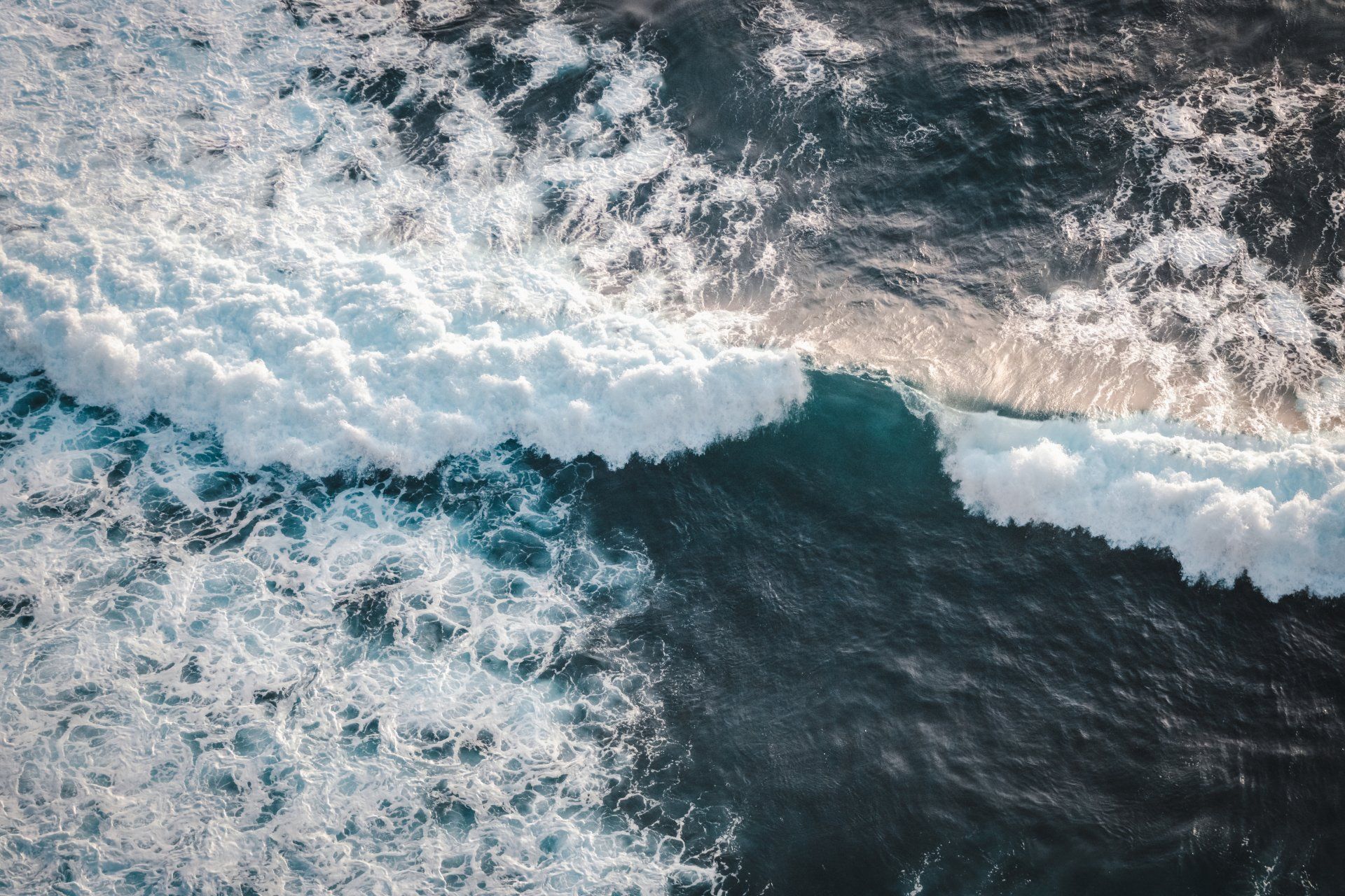 Ocean waves crashing with white foam over dark blue water