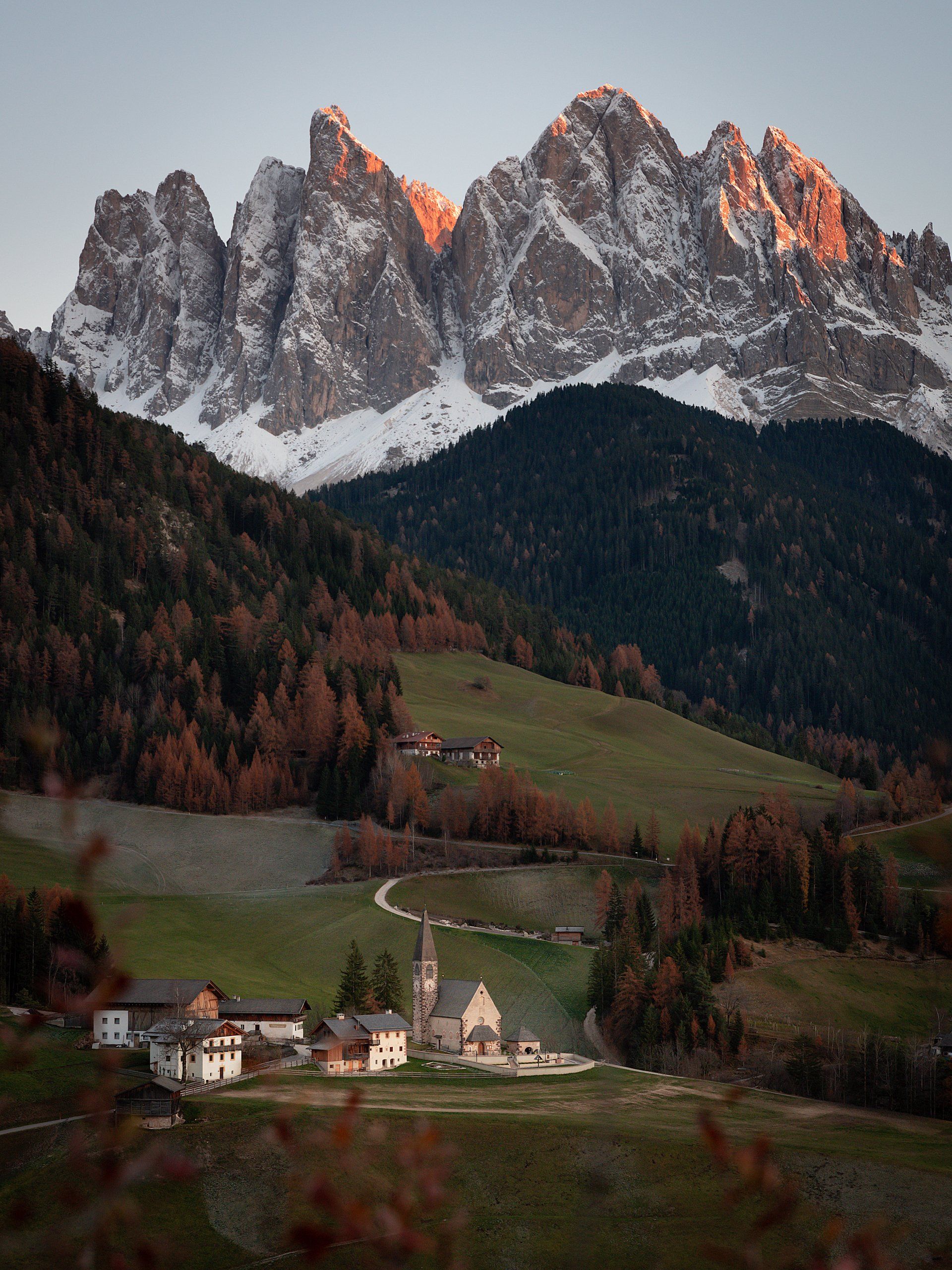 A small village in the middle of a valley with mountains in the background