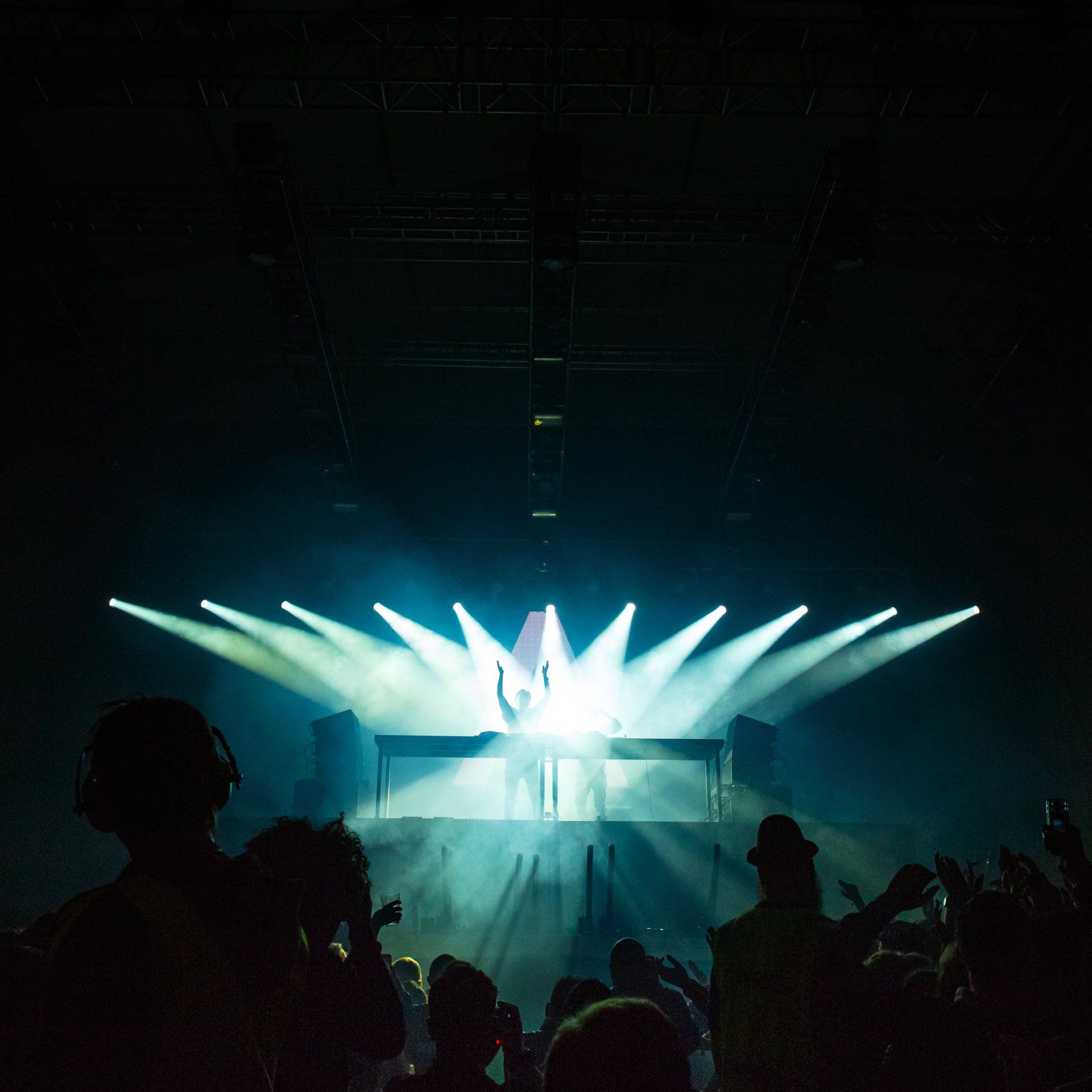 a crowd of people are watching a dj perform on stage