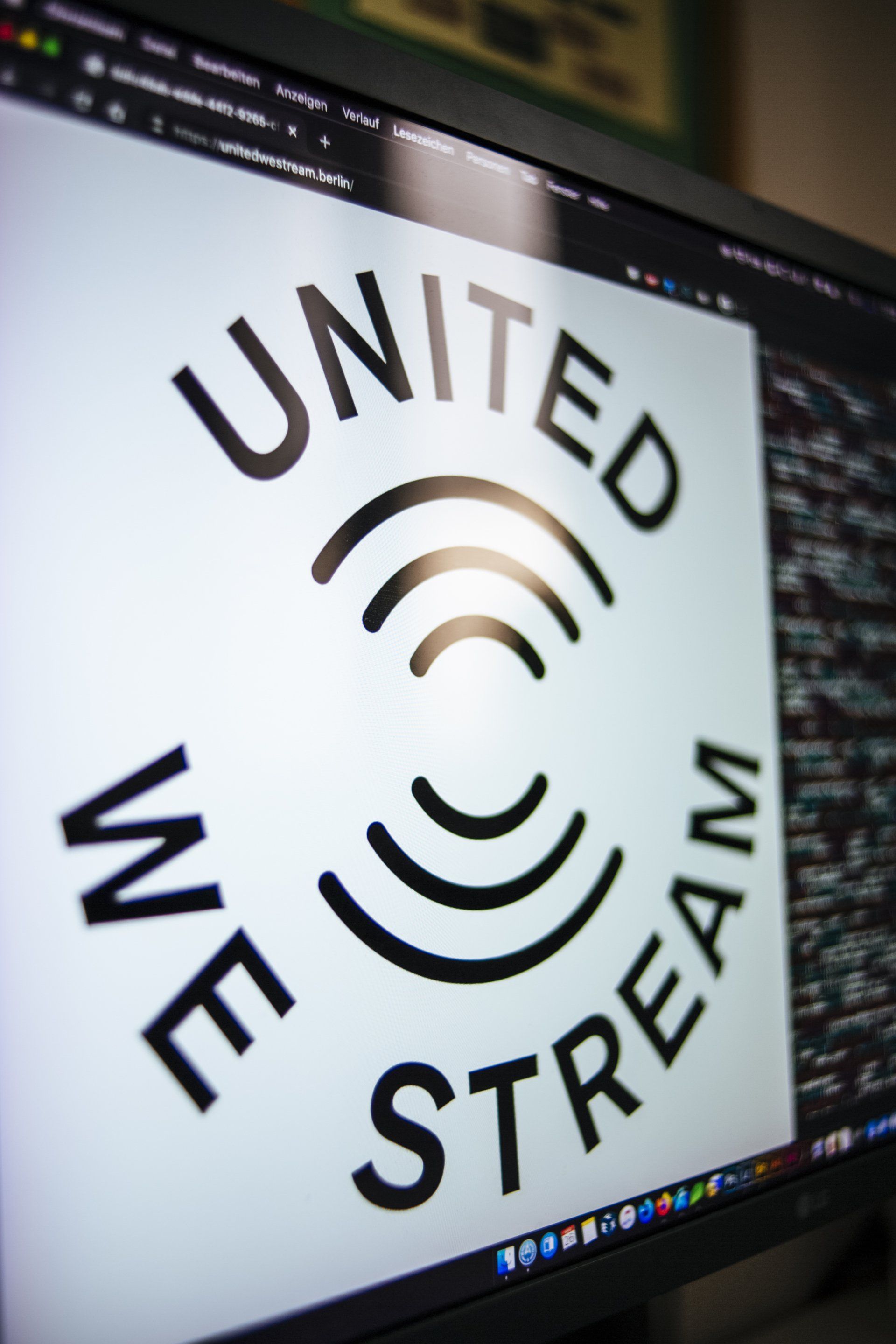 A computer monitor displays a logo for united stream