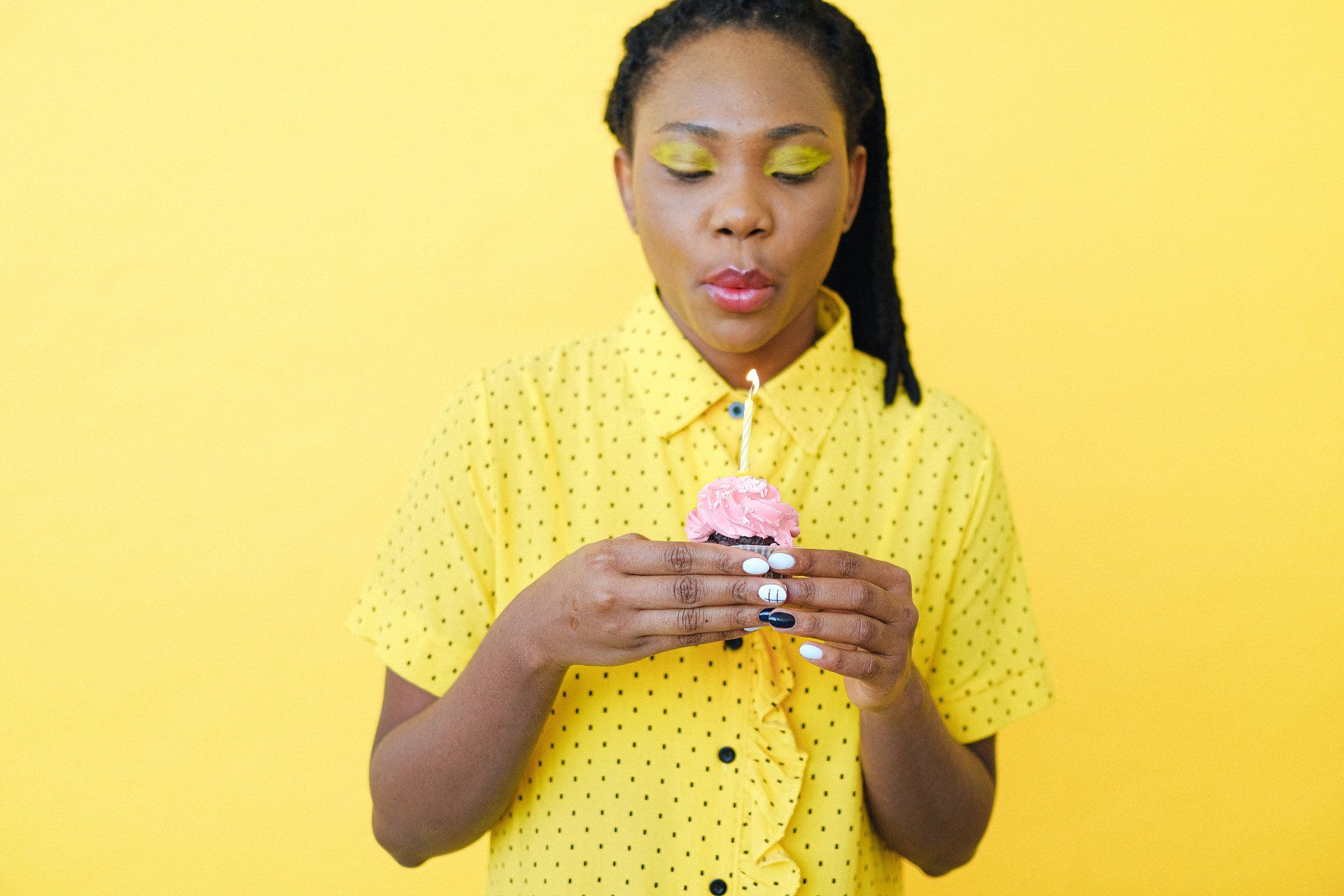 Young woman blowing out a birthday candle
