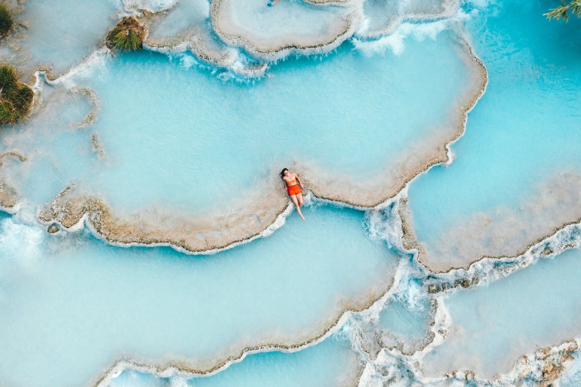 An aerial view of a person swimming in a pool of water.