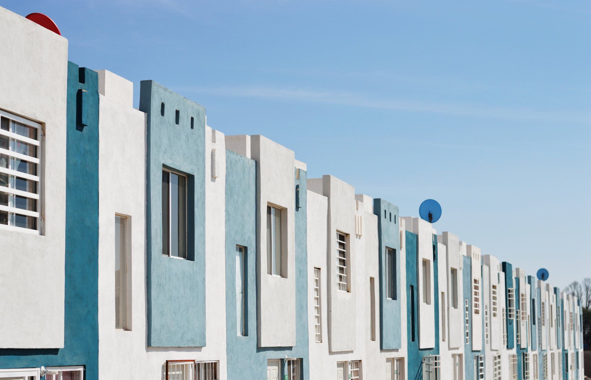 A row of blue and white buildings with a blue sky in the background