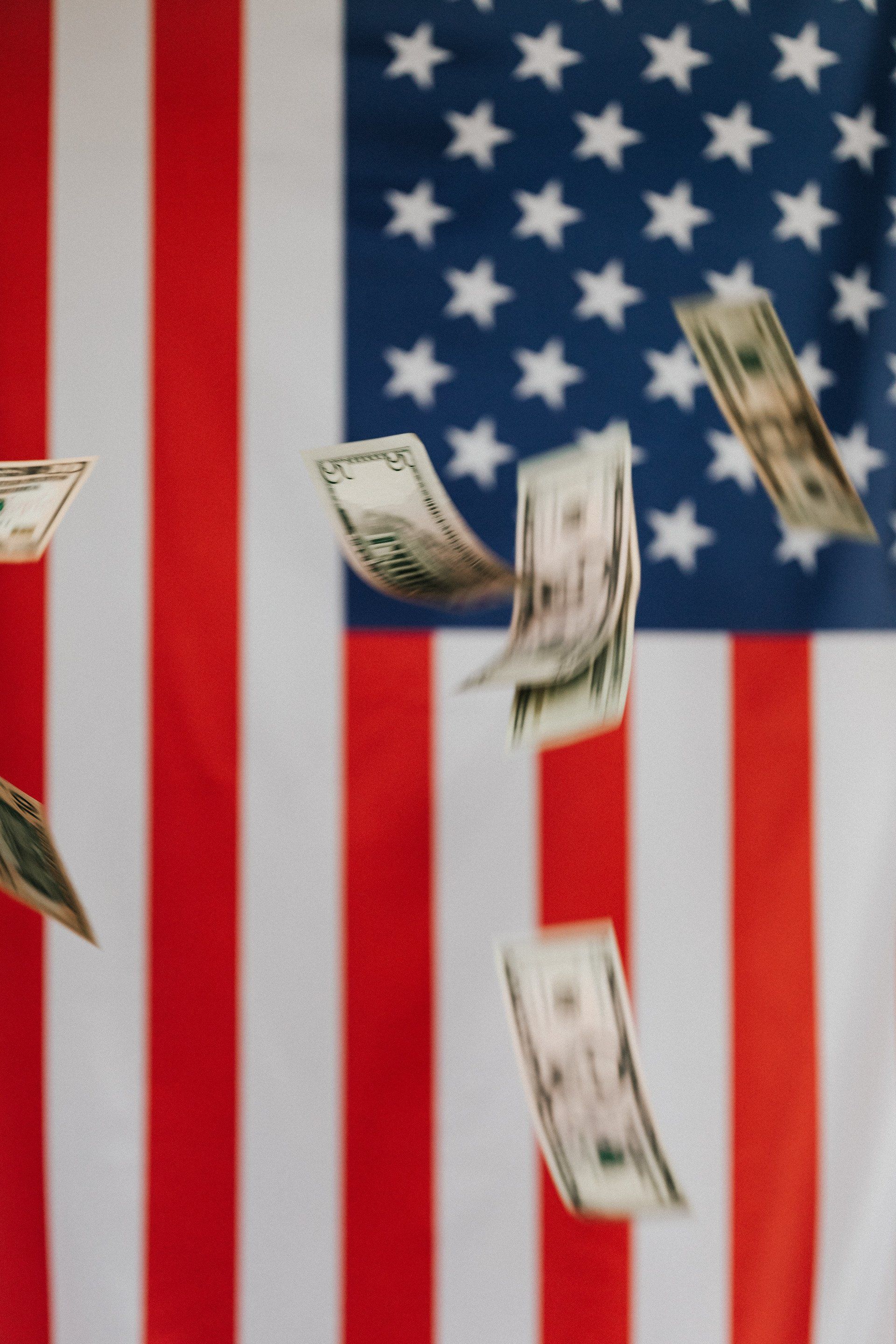 USA, red white and blue flag with dollar floating around