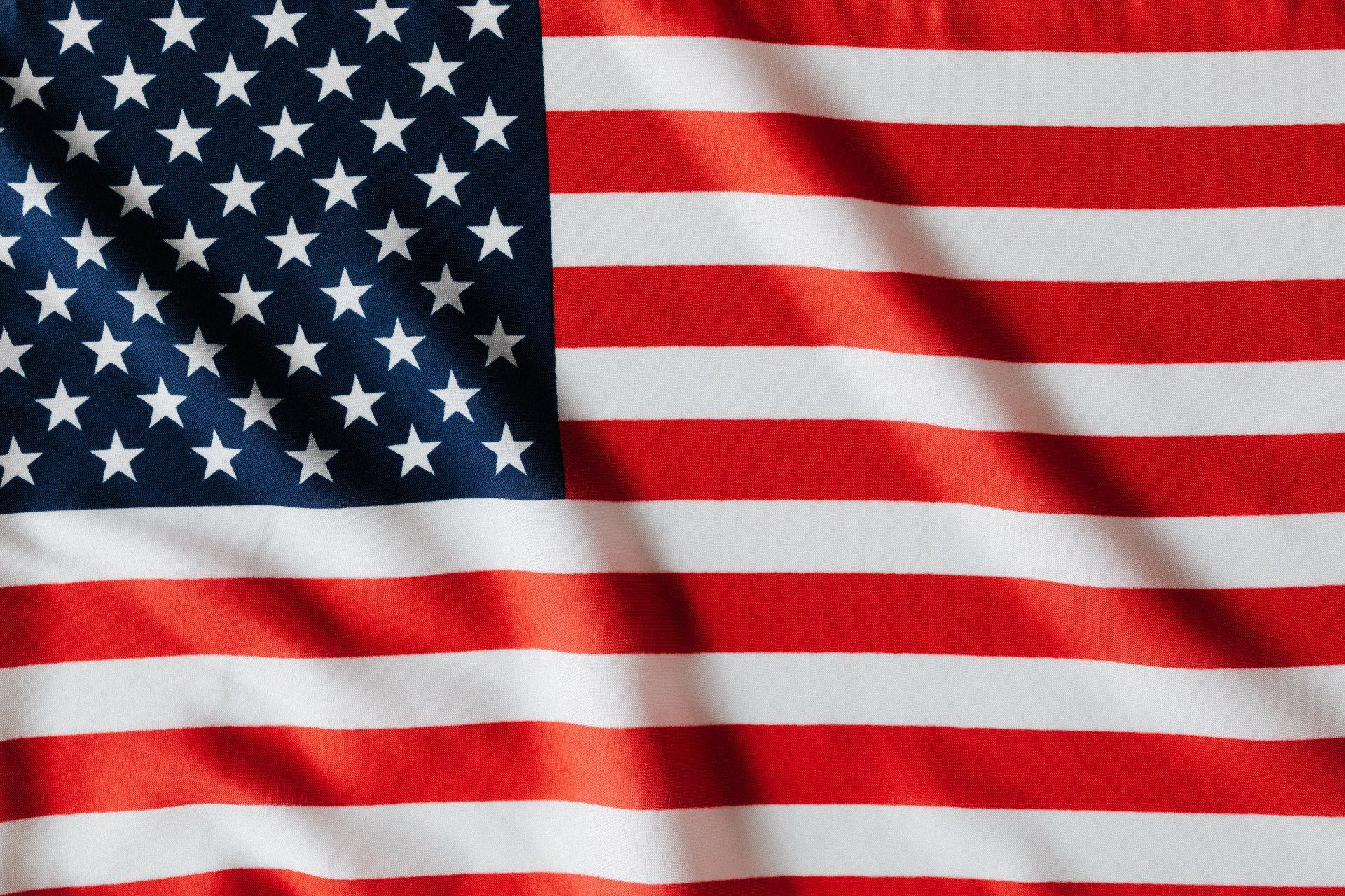 A close up of an american flag waving in the wind.