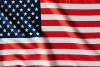 A close up of an american flag waving in the wind.