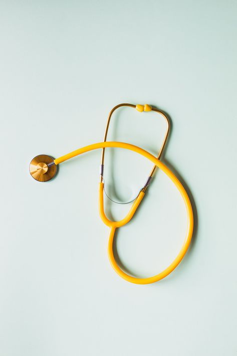Yellow stethoscope on a light blue background.