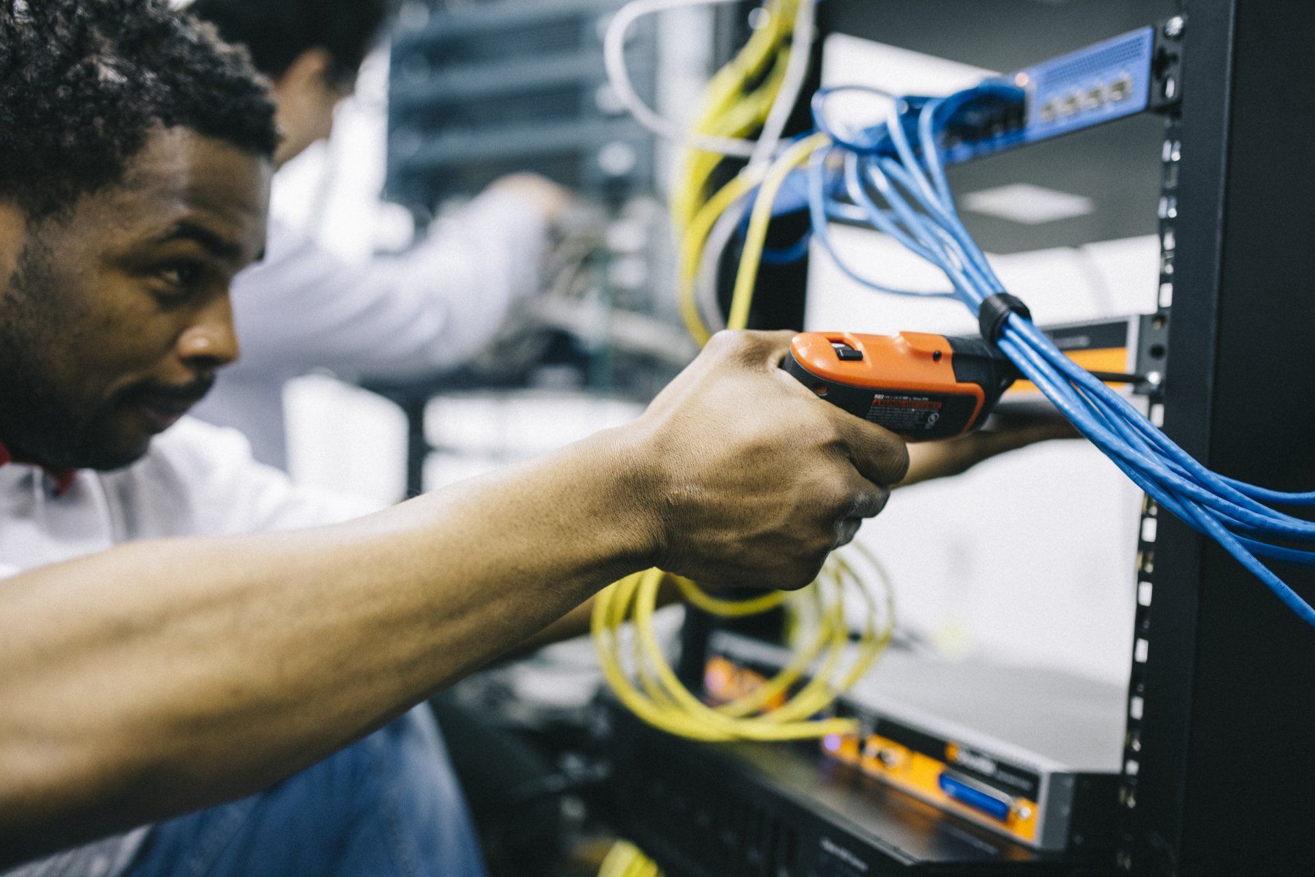 A man is working on a server with a screwdriver