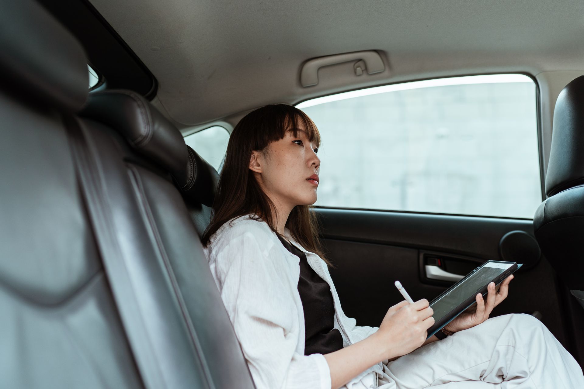 woman in car in Rochester reading a notebook
