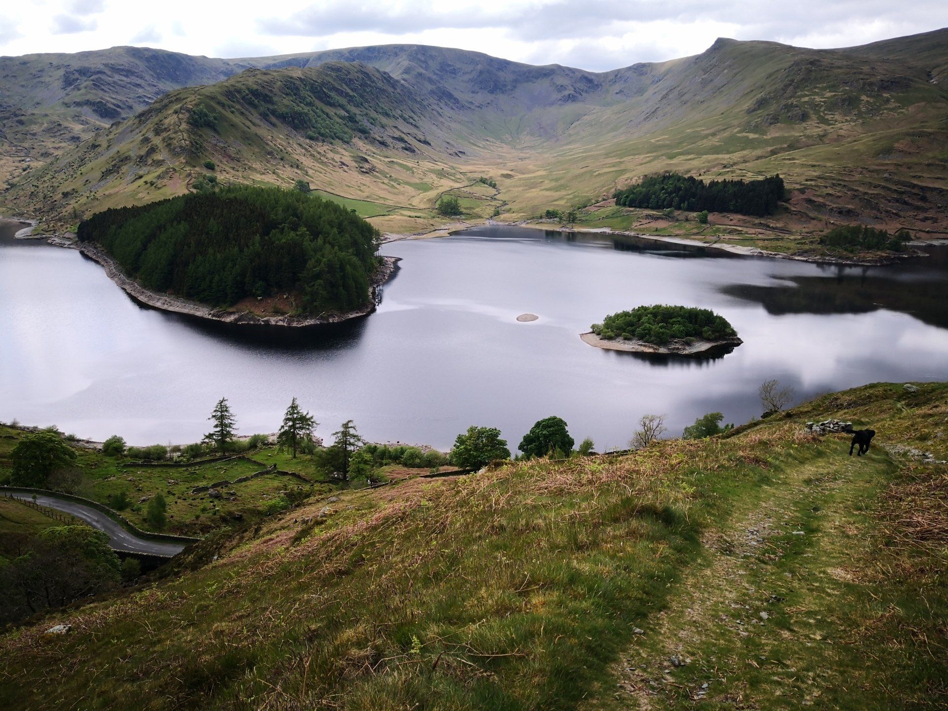 a lake with a small island in the middle of it surrounded by mountains .