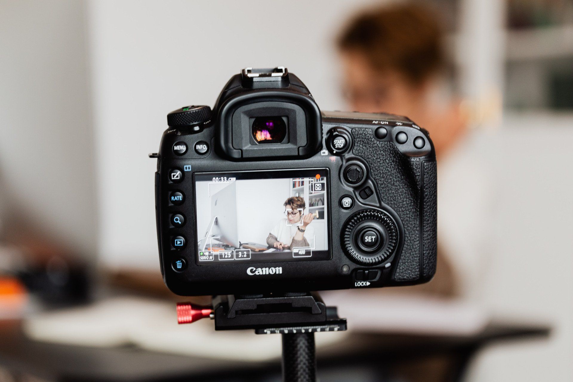 A camera is recording a video of a man sitting at a table.