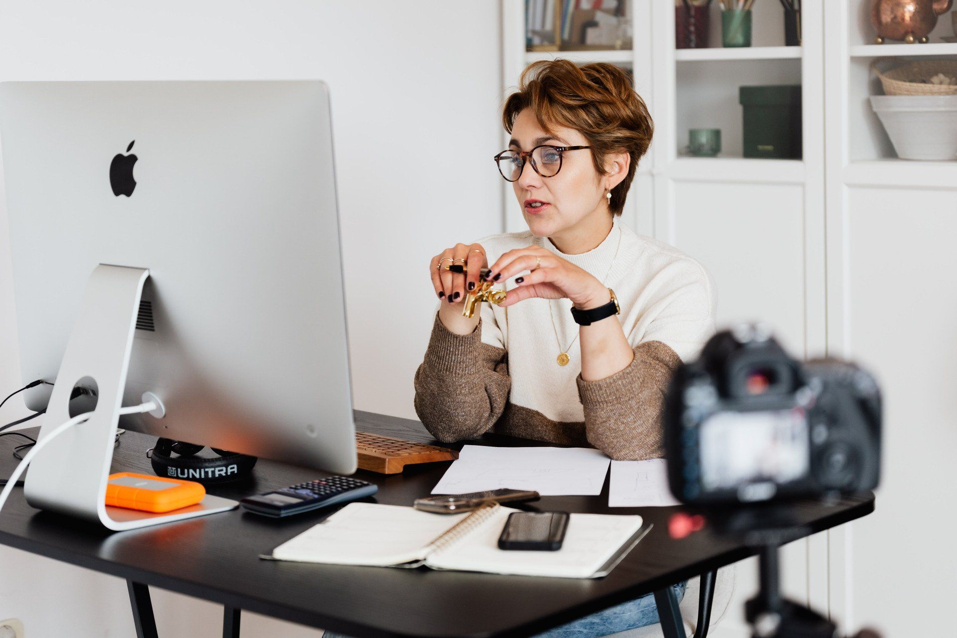 A woman is sitting at a desk in front of a computer.