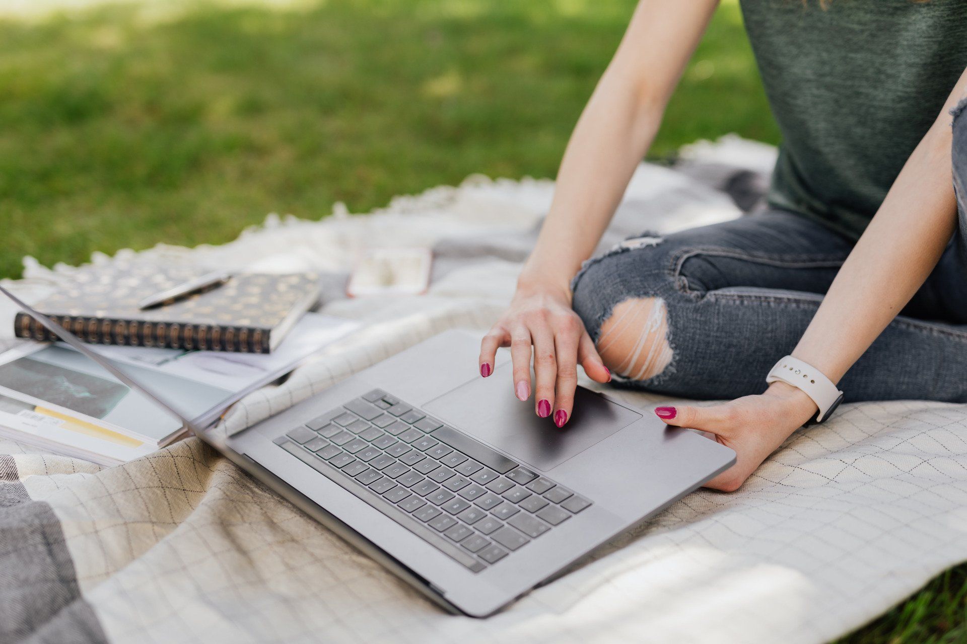 A person on a laptop outside on a blanket in the springtime in Vermont