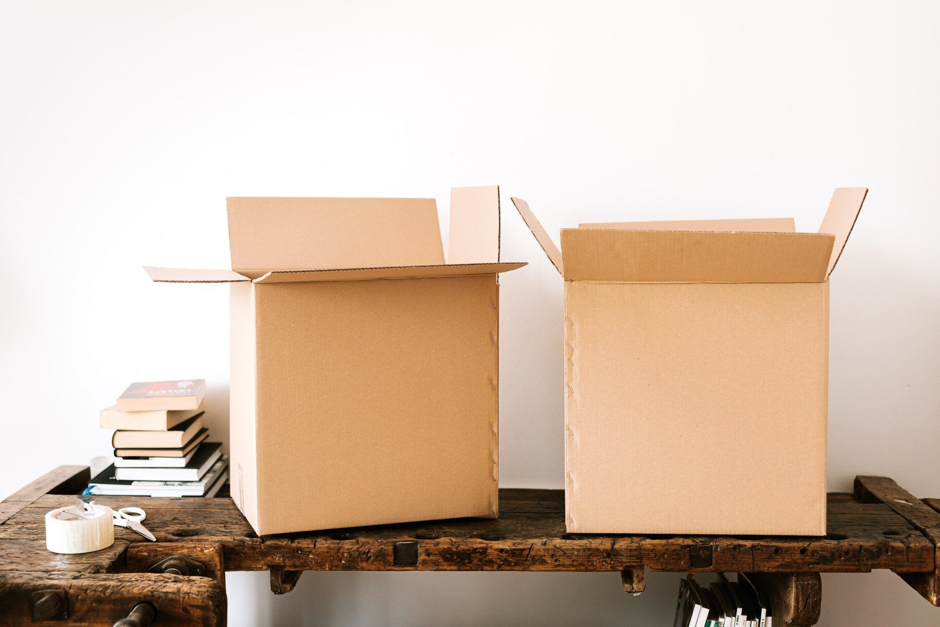 Two cardboard boxes are sitting on a wooden table.