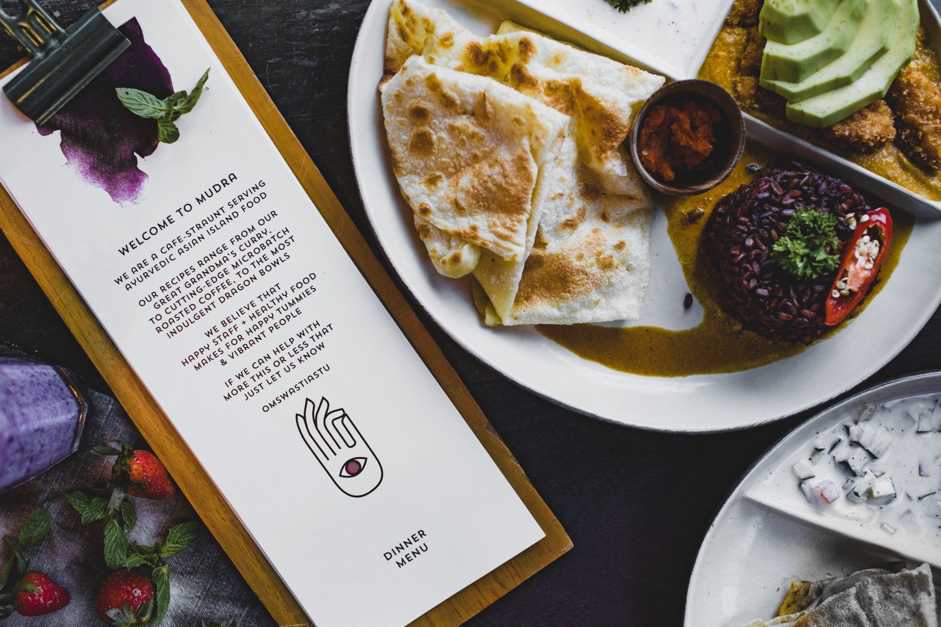 A plate of food is sitting on a table next to a menu.