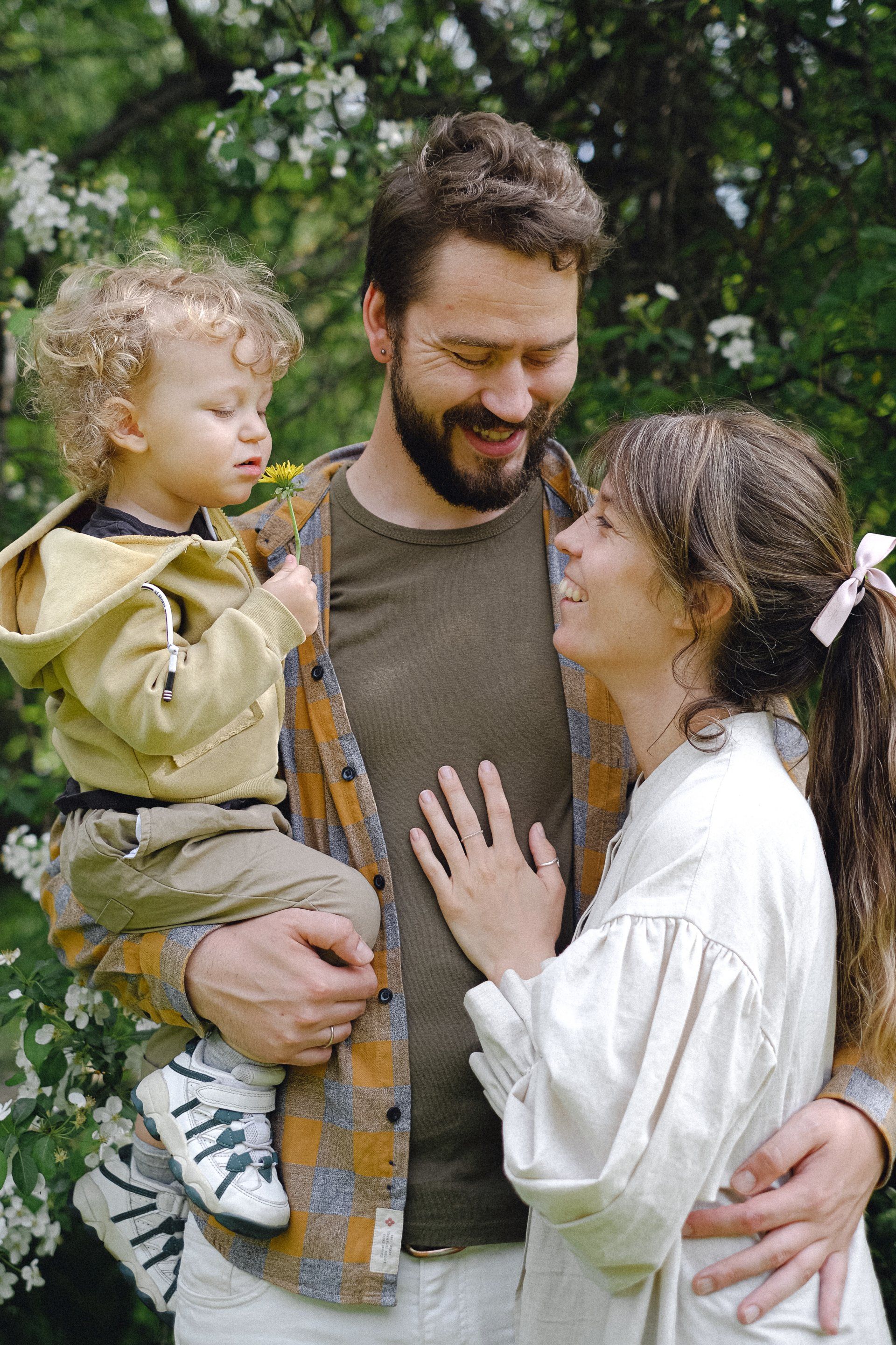 A man and a woman are holding a baby in their arms.