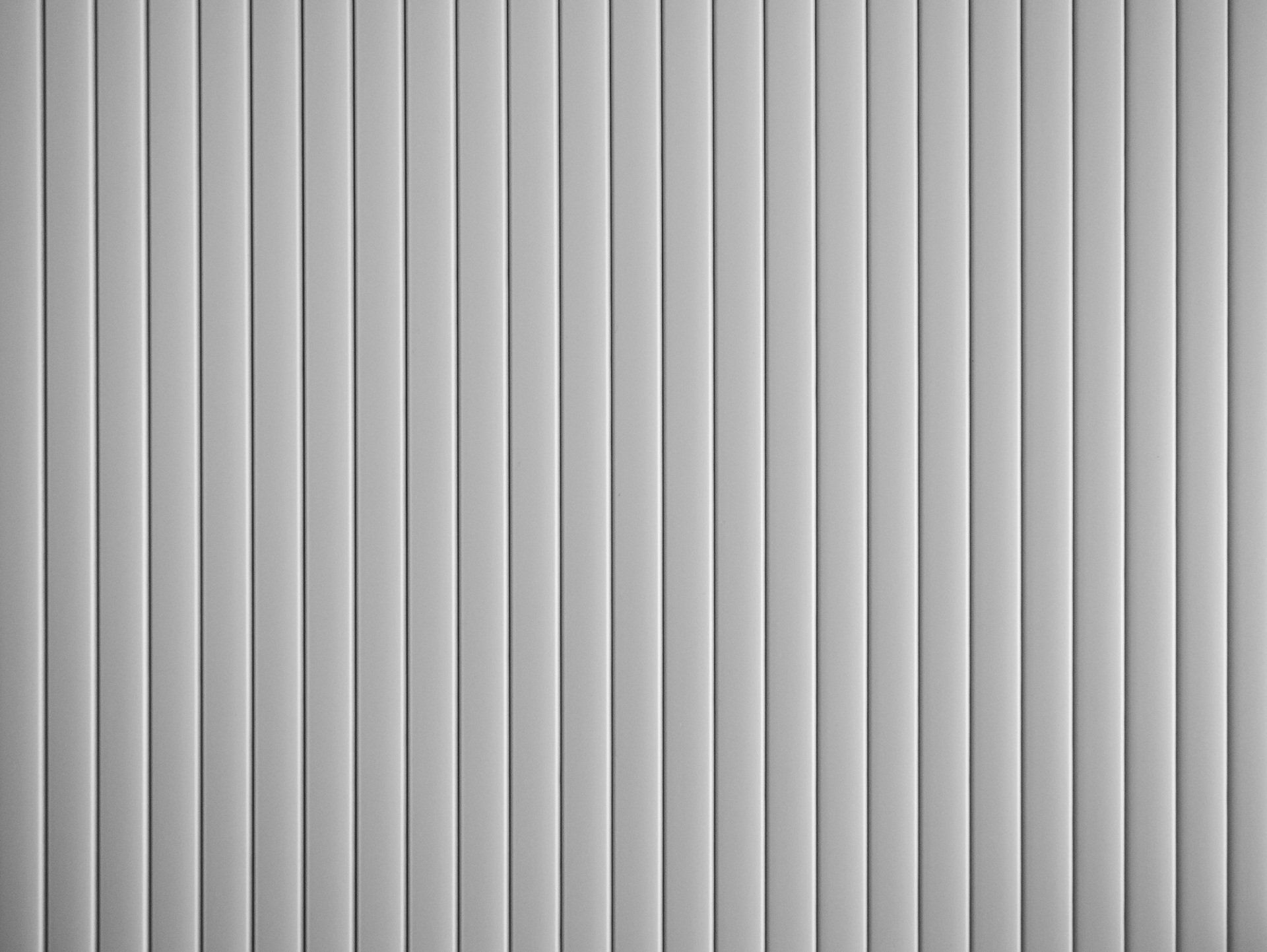A close up of a white vertical blind on a window.