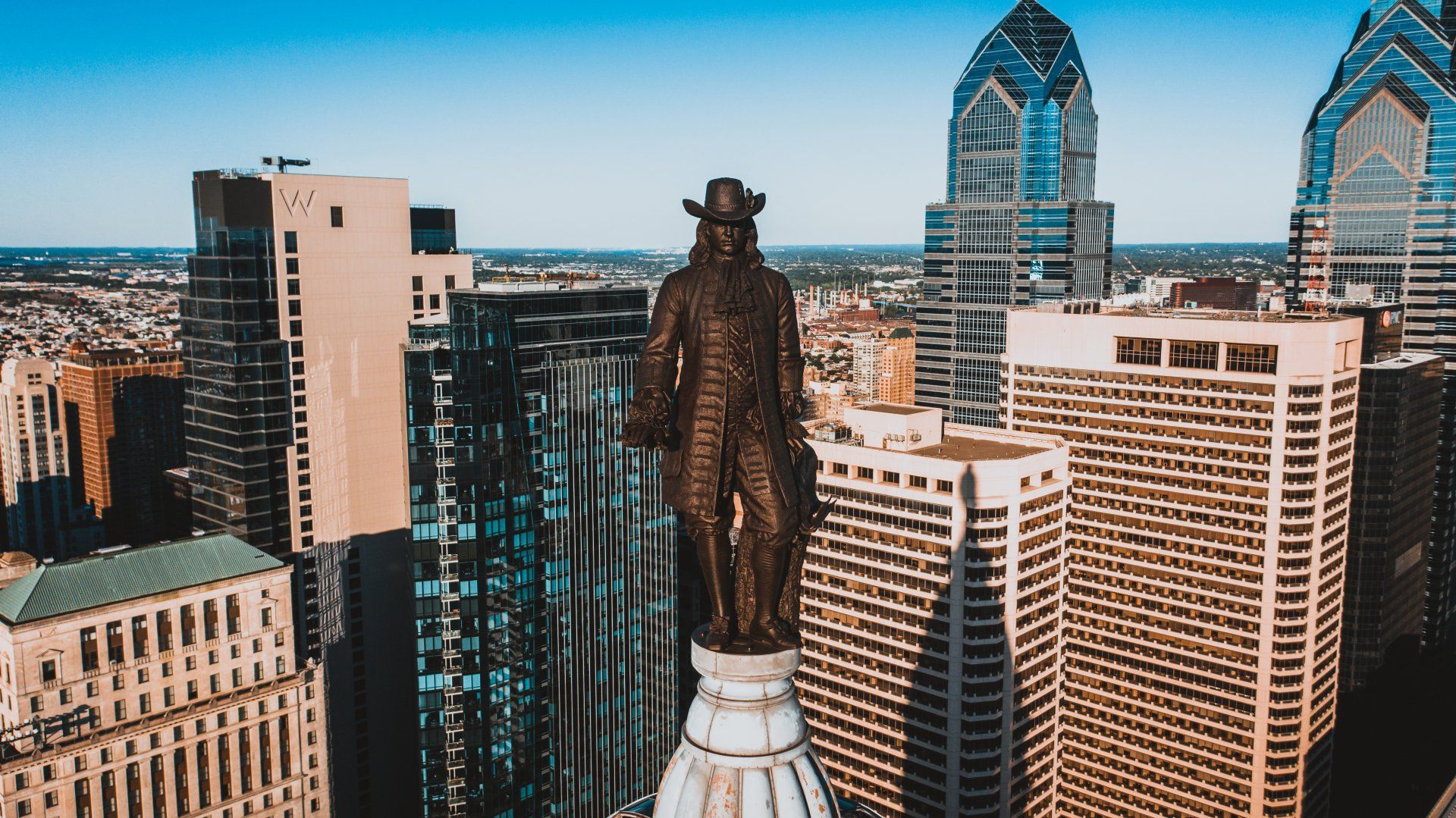 An aerial view of a city with a statue of a man on top of a building.